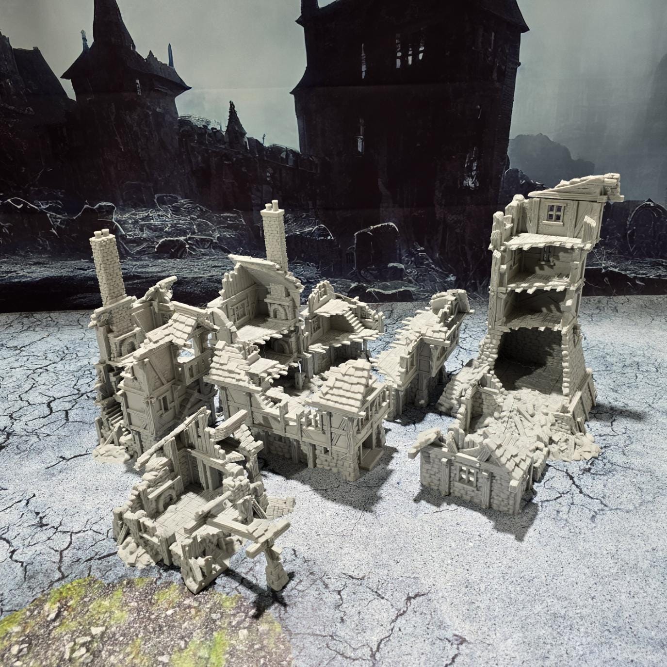 three intricately detailed ruined buildings and a towering structure, showcasing crumbling stone walls, exposed beams, and a hauntingly desolate atmosphere, perfect for bringing medieval and fantasy battles to life on your tabletop.