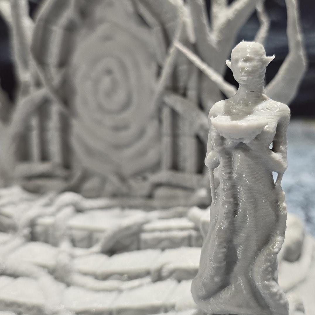 The Elven Portal model features a detailed fantasy gateway flanked by two statues, with intricate root and branch designs, perfect for enhancing fantasy tabletop settings.