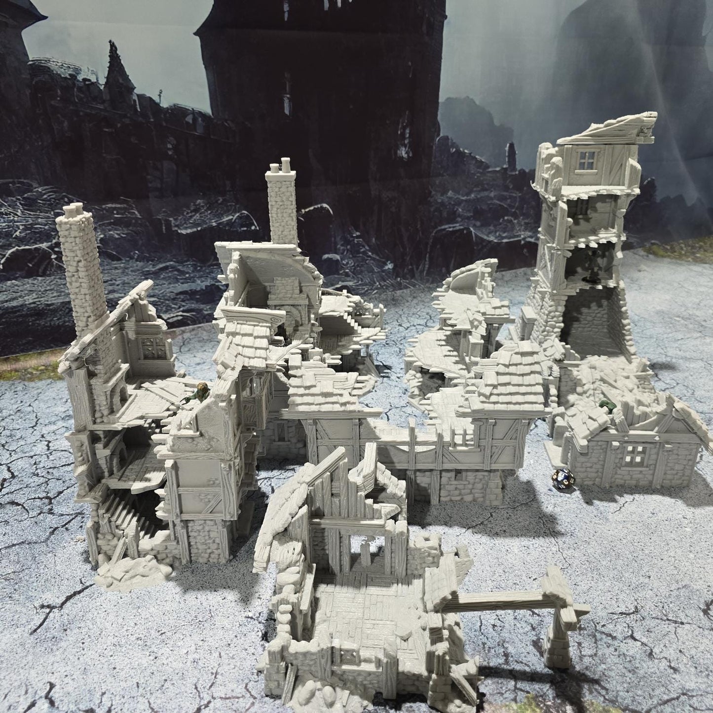three intricately detailed ruined buildings and a towering structure, showcasing crumbling stone walls, exposed beams, and a hauntingly desolate atmosphere, perfect for bringing medieval and fantasy battles to life on your tabletop.
