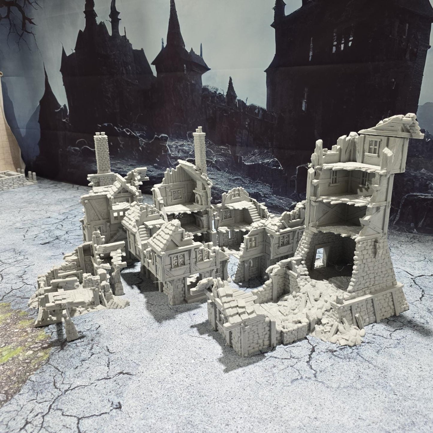 three intricately detailed ruined buildings and a towering structure, showcasing crumbling stone walls, exposed beams, and a hauntingly desolate atmosphere, perfect for bringing medieval and fantasy battles to life on your tabletop.
