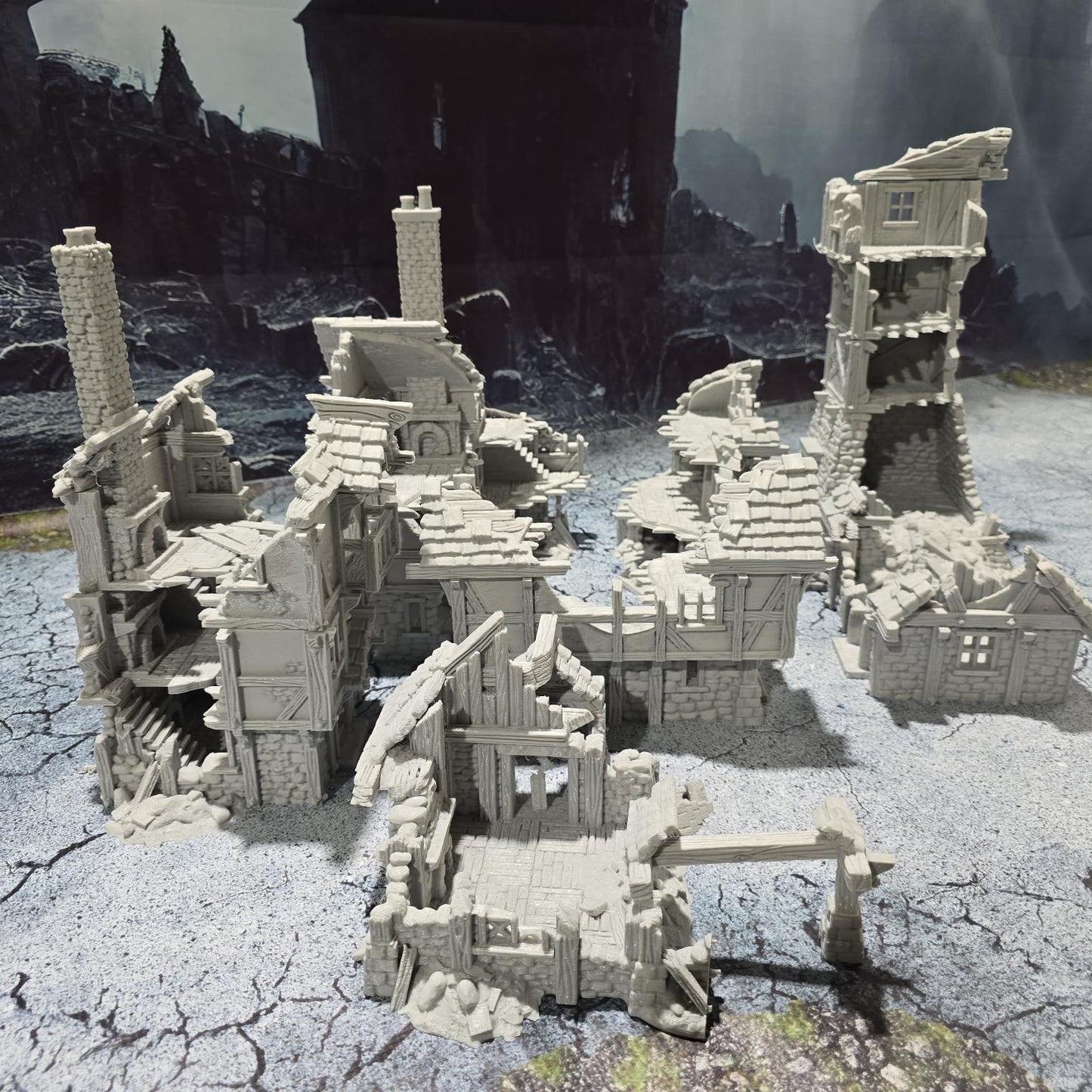 three intricately detailed ruined buildings and a towering structure, showcasing crumbling stone walls, exposed beams, and a hauntingly desolate atmosphere, perfect for bringing medieval and fantasy battles to life on your tabletop.