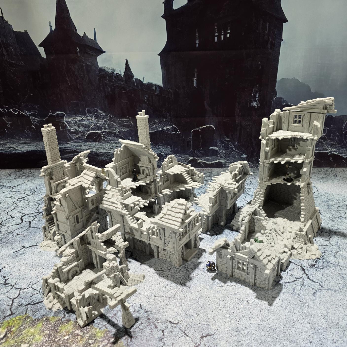 three intricately detailed ruined buildings and a towering structure, showcasing crumbling stone walls, exposed beams, and a hauntingly desolate atmosphere, perfect for bringing medieval and fantasy battles to life on your tabletop.