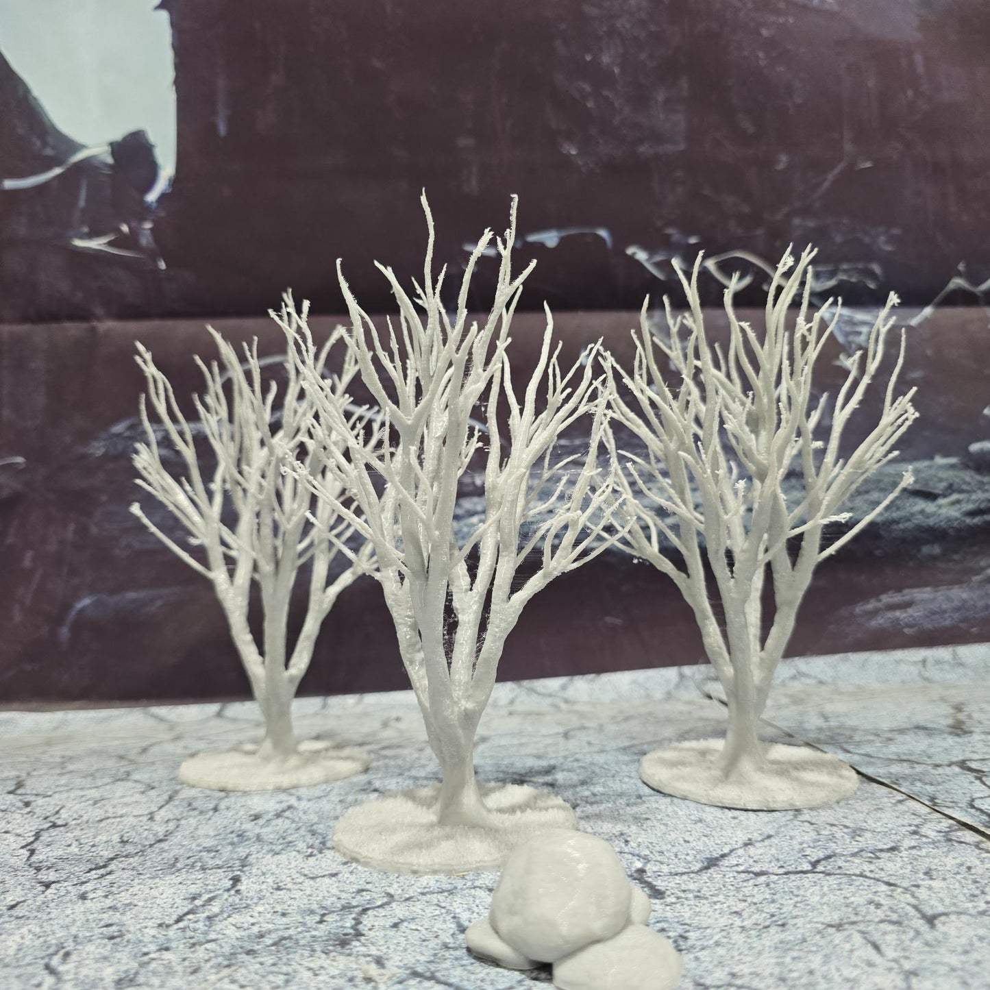 A set of 3 bare trees, each featuring intricate branches and a stable base. Perfect for creating desolate or haunted landscapes in tabletop RPGs and dioramas. Ideal for use in wintery or eerie settings.