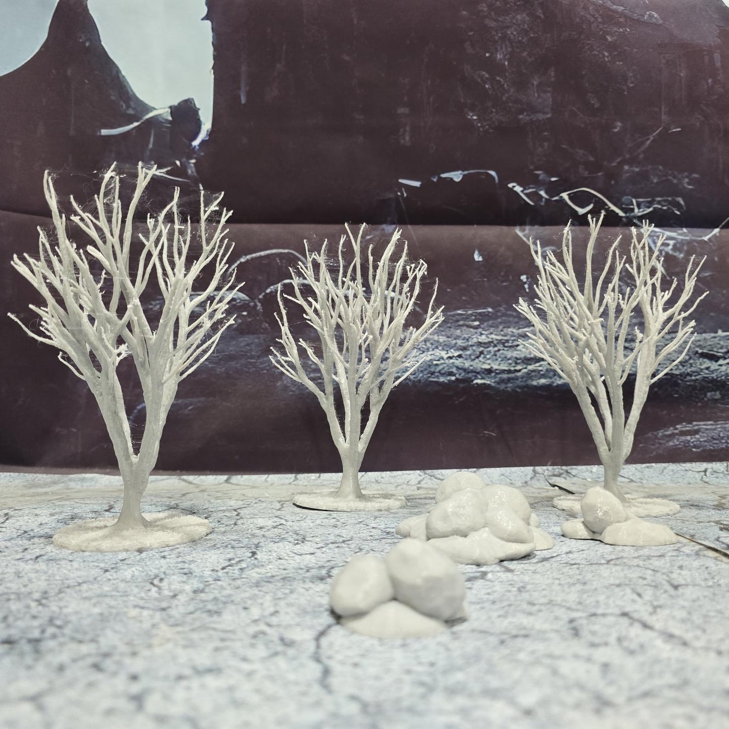 A set of 3 bare trees, each featuring intricate branches and a stable base. Perfect for creating desolate or haunted landscapes in tabletop RPGs and dioramas. Ideal for use in wintery or eerie settings.