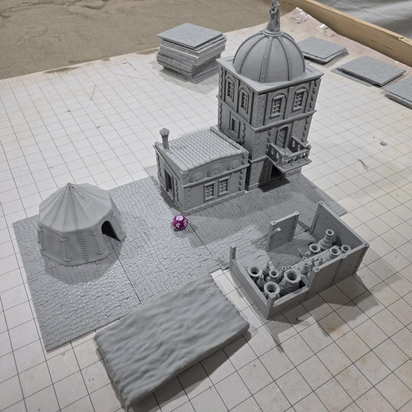 Complete medieval street set with two detailed buildings, a market tent and stall, and five cobblestone roads, perfect for tabletop role-playing games.
