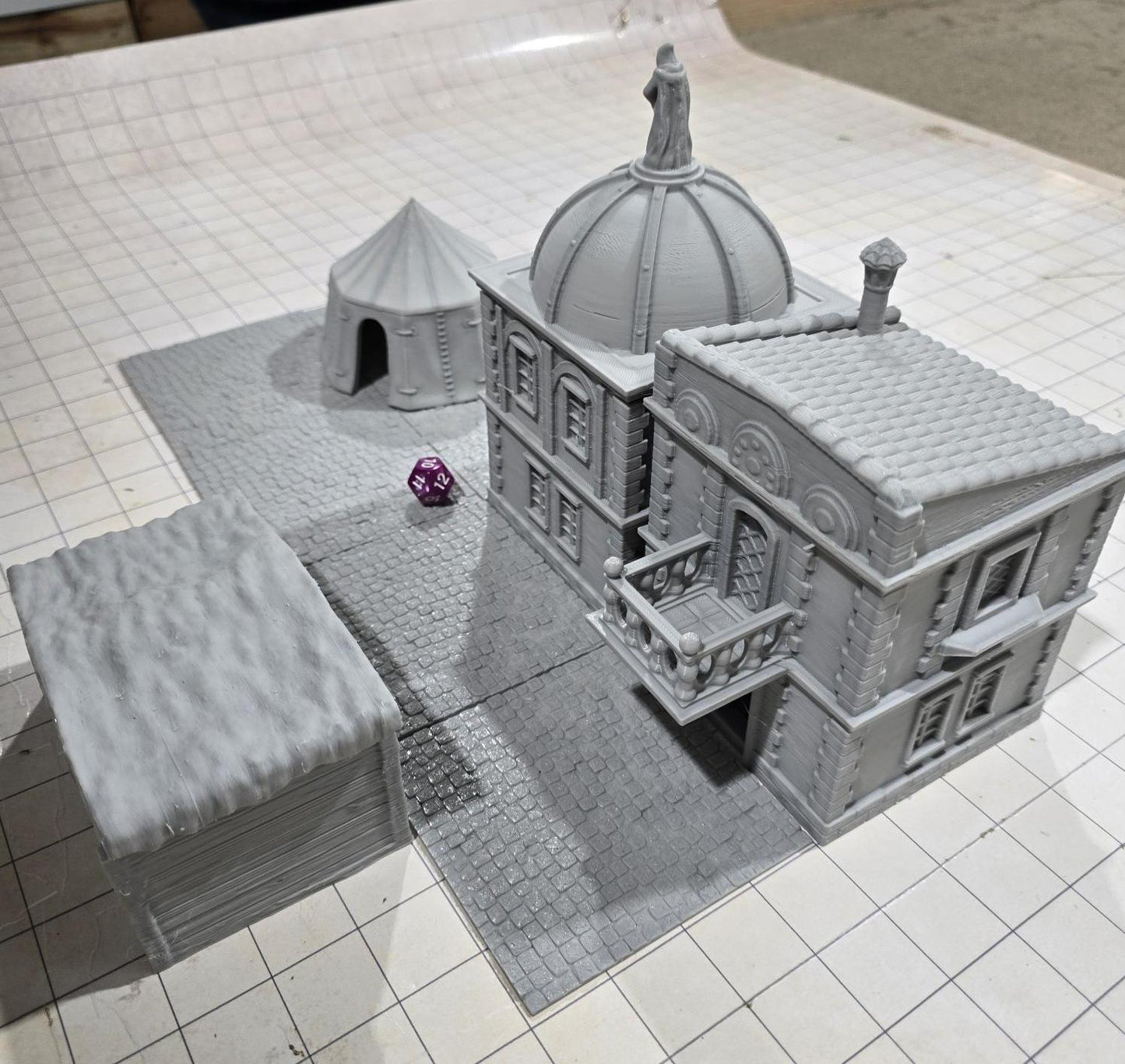 Complete medieval street set with two detailed buildings, a market tent and stall, and five cobblestone roads, perfect for tabletop role-playing games.