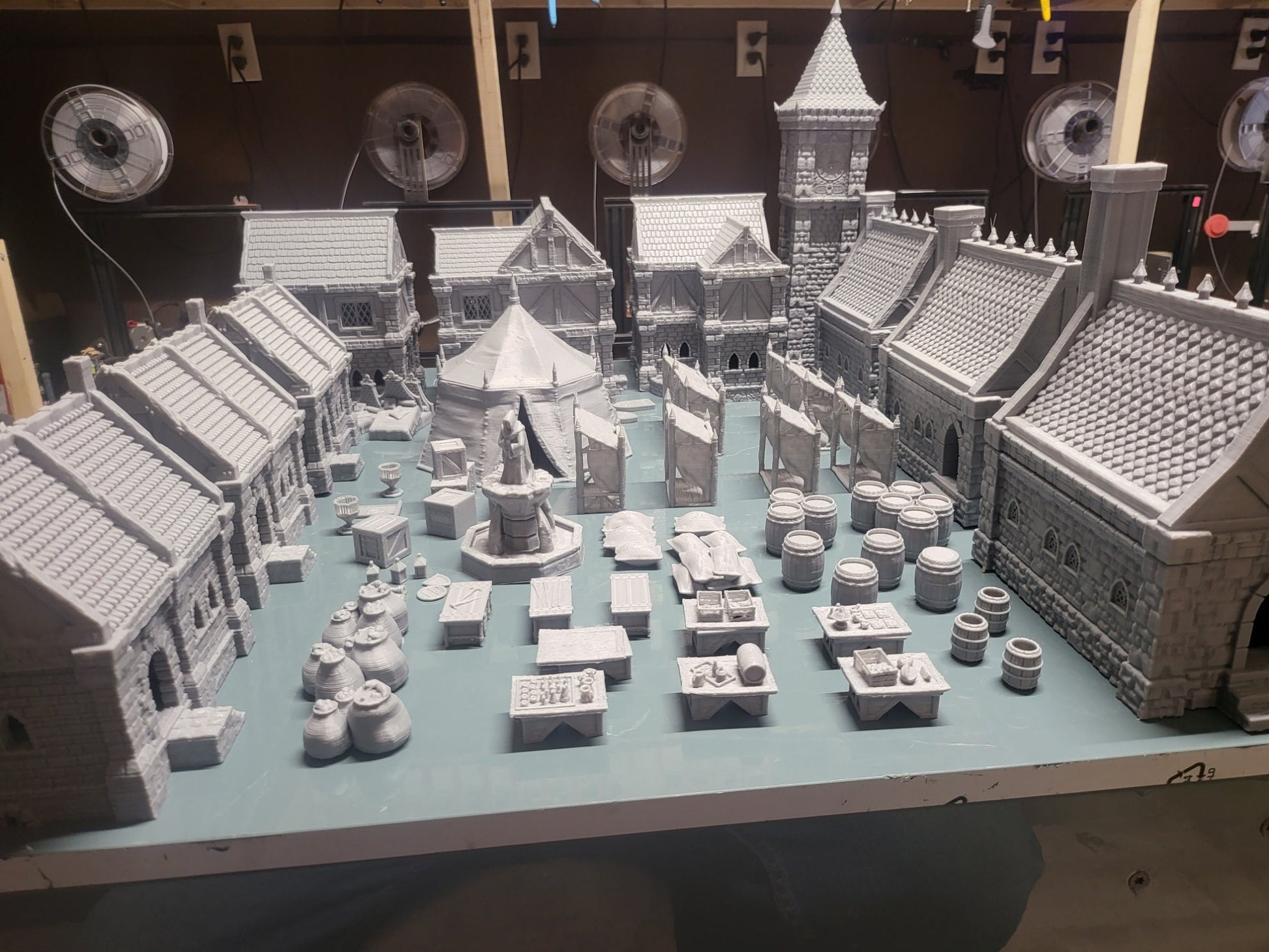 Set of 10 detailed 28mm buildings for tabletop RPGs, featuring wooden and stone structures with varied roof styles. Includes market wares and scatter terrain like barrels and crates. Perfect for village scenes in D&D, Pathfinder, and Warhammer.