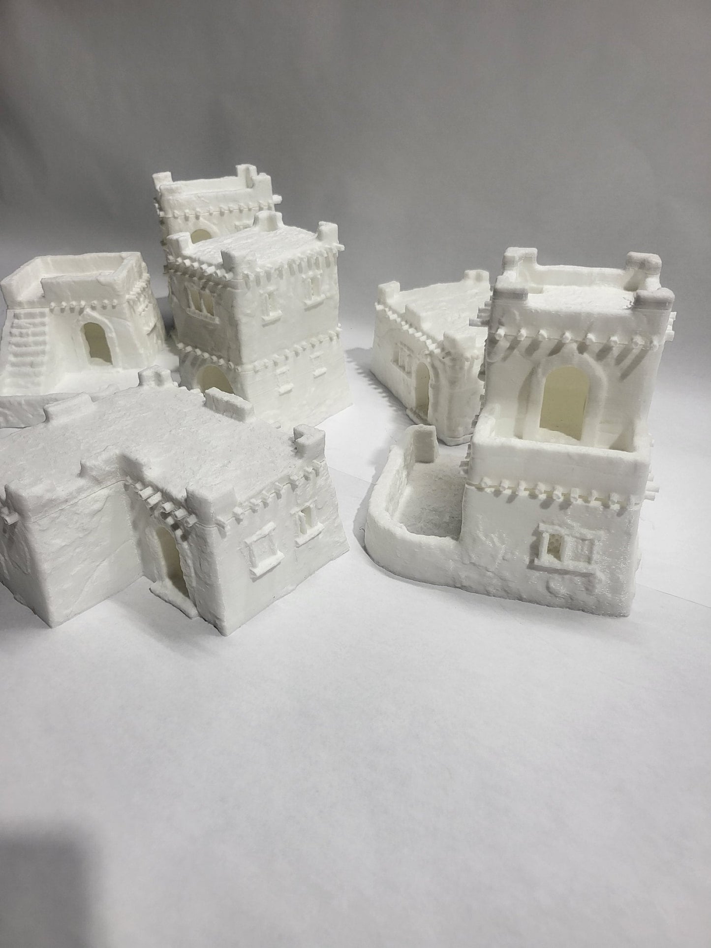 Detailed 28mm desert mud house set for tabletop RPGs, featuring various buildings and terrain pieces with intricate designs. Perfect for creating immersive desert village scenes in games like D&D and Pathfinder.