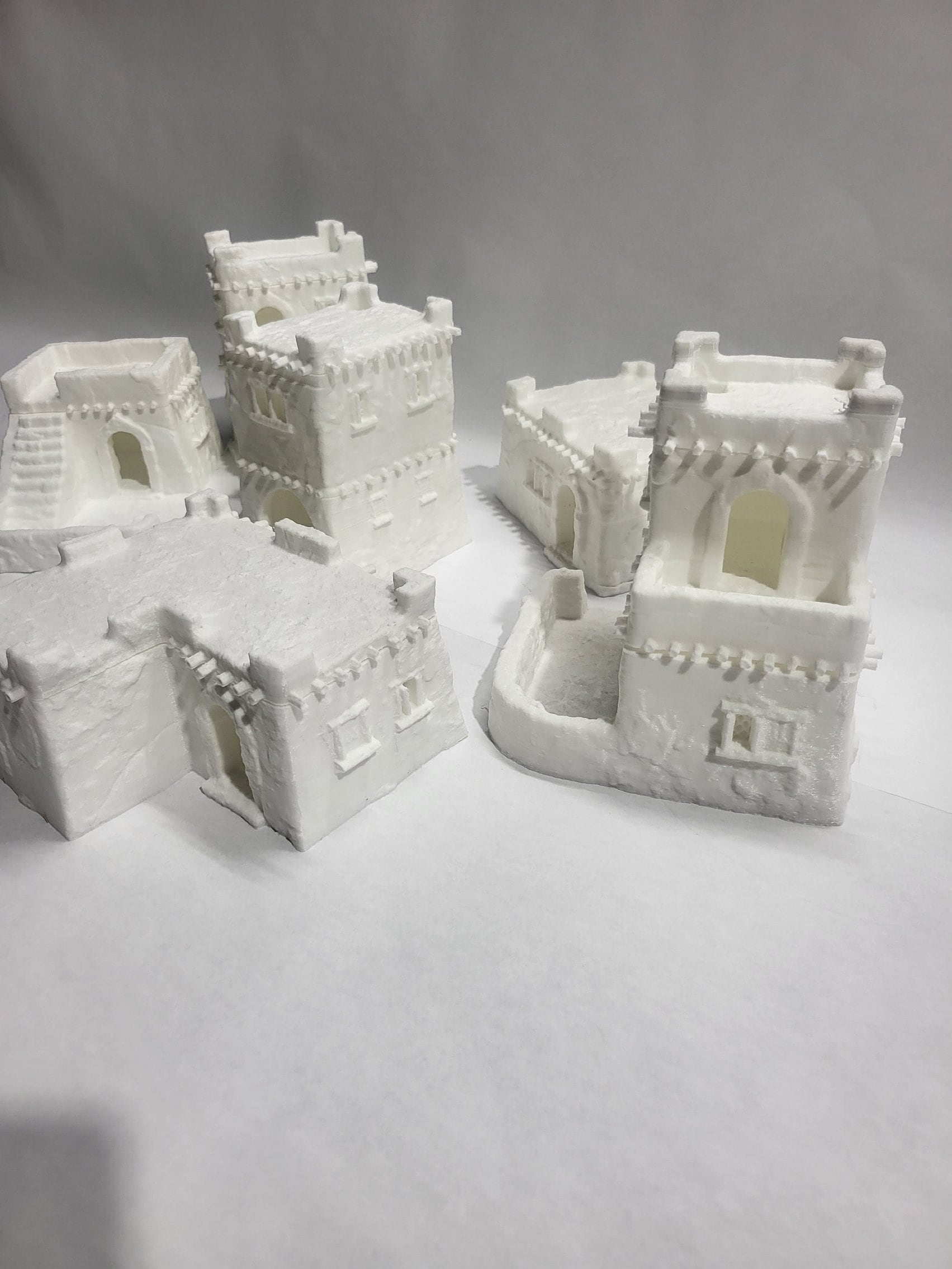 Detailed 28mm desert mud house set for tabletop RPGs, featuring various buildings and terrain pieces with intricate designs. Perfect for creating immersive desert village scenes in games like D&D and Pathfinder.