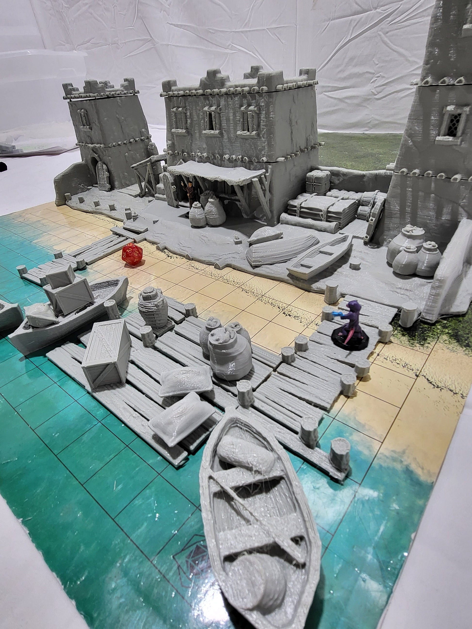Detailed 28mm desert dock and port set for tabletop RPGs, featuring various buildings and dock structures with intricate designs. Perfect for creating immersive port scenes in games like D&D and Pathfinder.