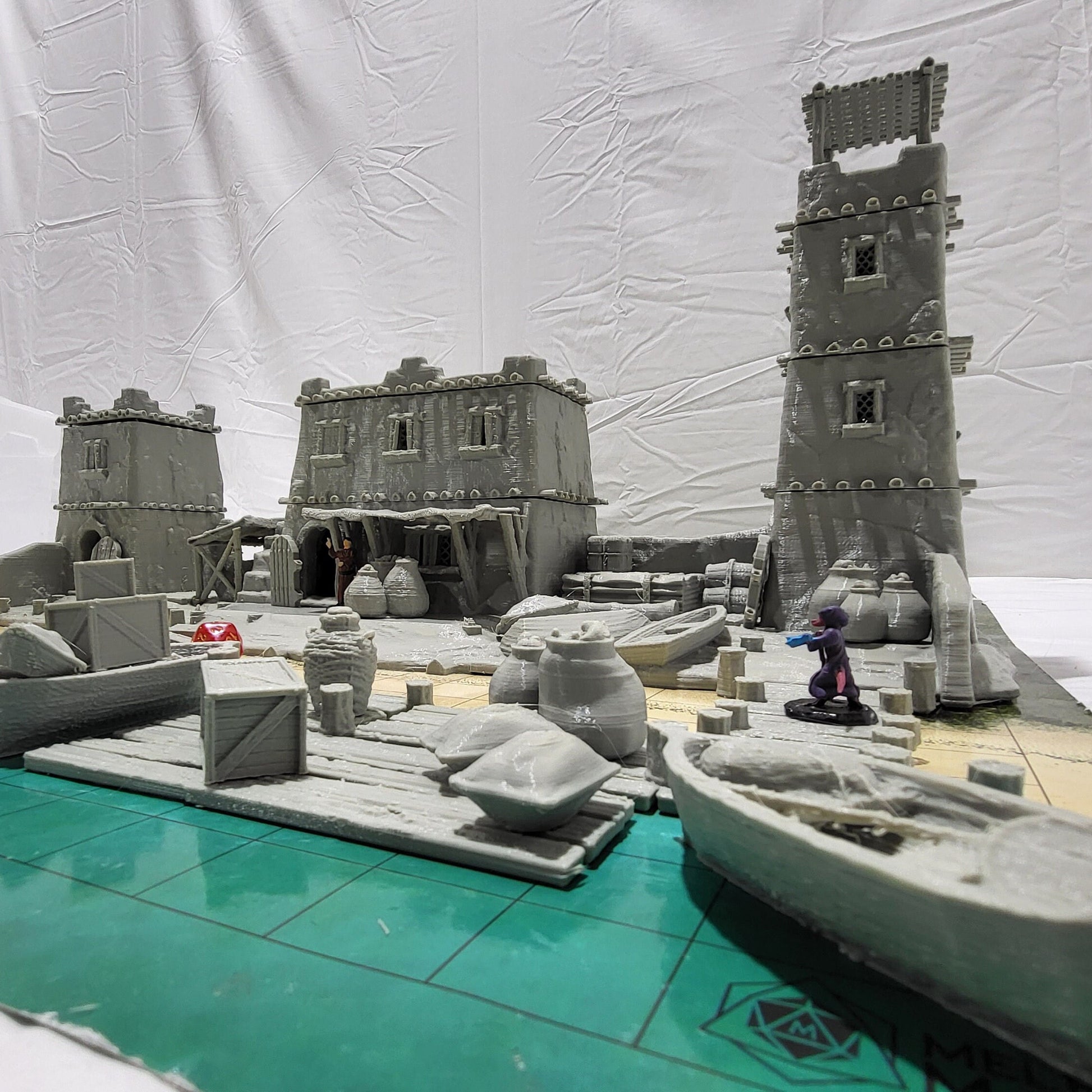 Detailed 28mm desert dock and port set for tabletop RPGs, featuring various buildings and dock structures with intricate designs. Perfect for creating immersive port scenes in games like D&D and Pathfinder.