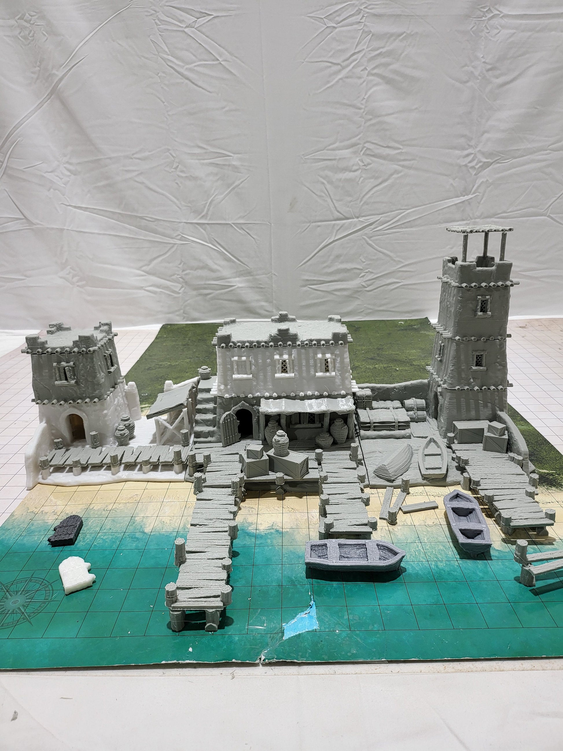 Detailed 28mm desert dock and port set for tabletop RPGs, featuring various buildings and dock structures with intricate designs. Perfect for creating immersive port scenes in games like D&D and Pathfinder.
