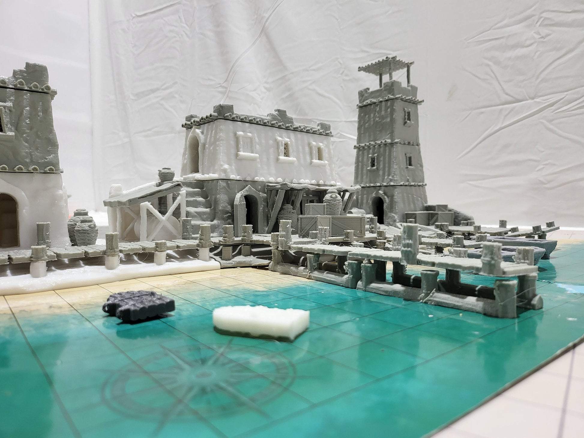 Detailed 28mm desert dock and port set for tabletop RPGs, featuring various buildings and dock structures with intricate designs. Perfect for creating immersive port scenes in games like D&D and Pathfinder.