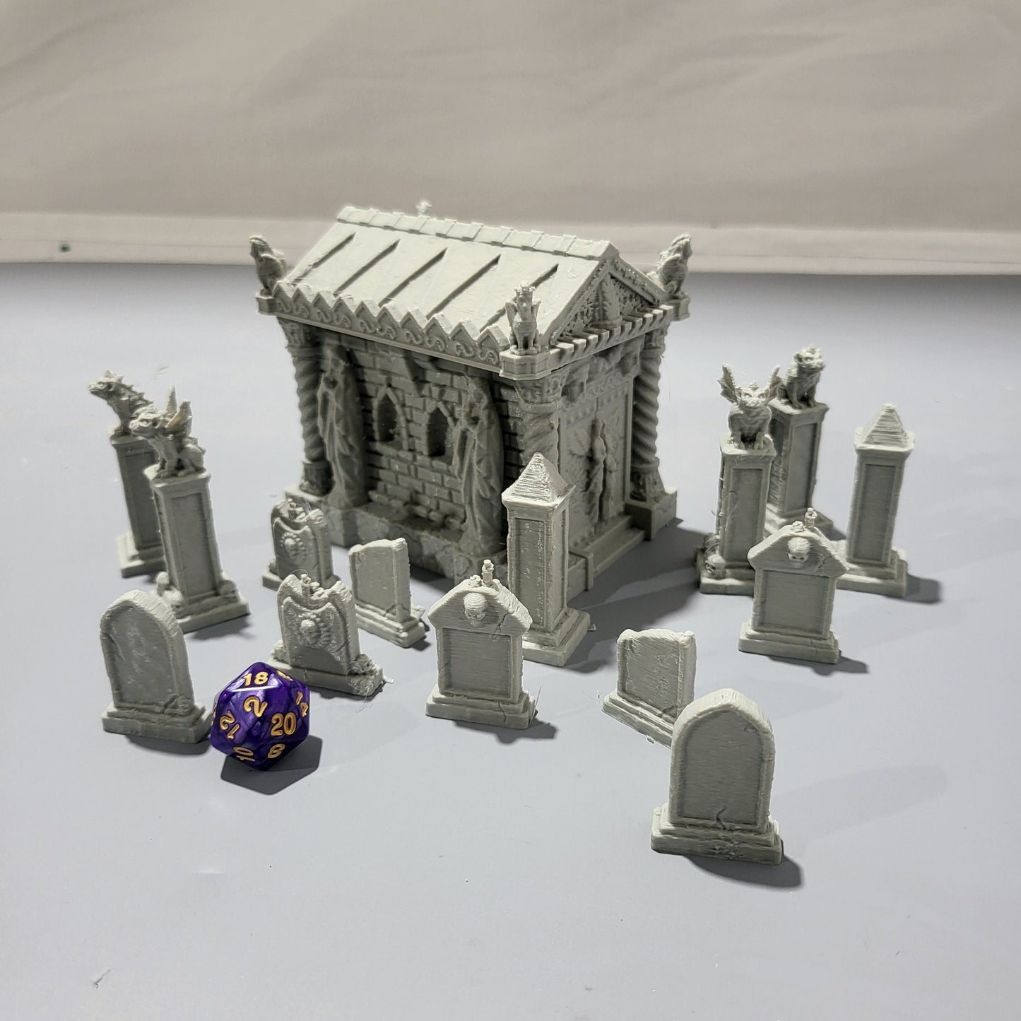 Detailed 15-piece cemetery set for tabletop RPGs, featuring a mausoleum and various gravestones. Perfect for creating eerie graveyard scenes in games like D&D, Pathfinder, and Warhammer.