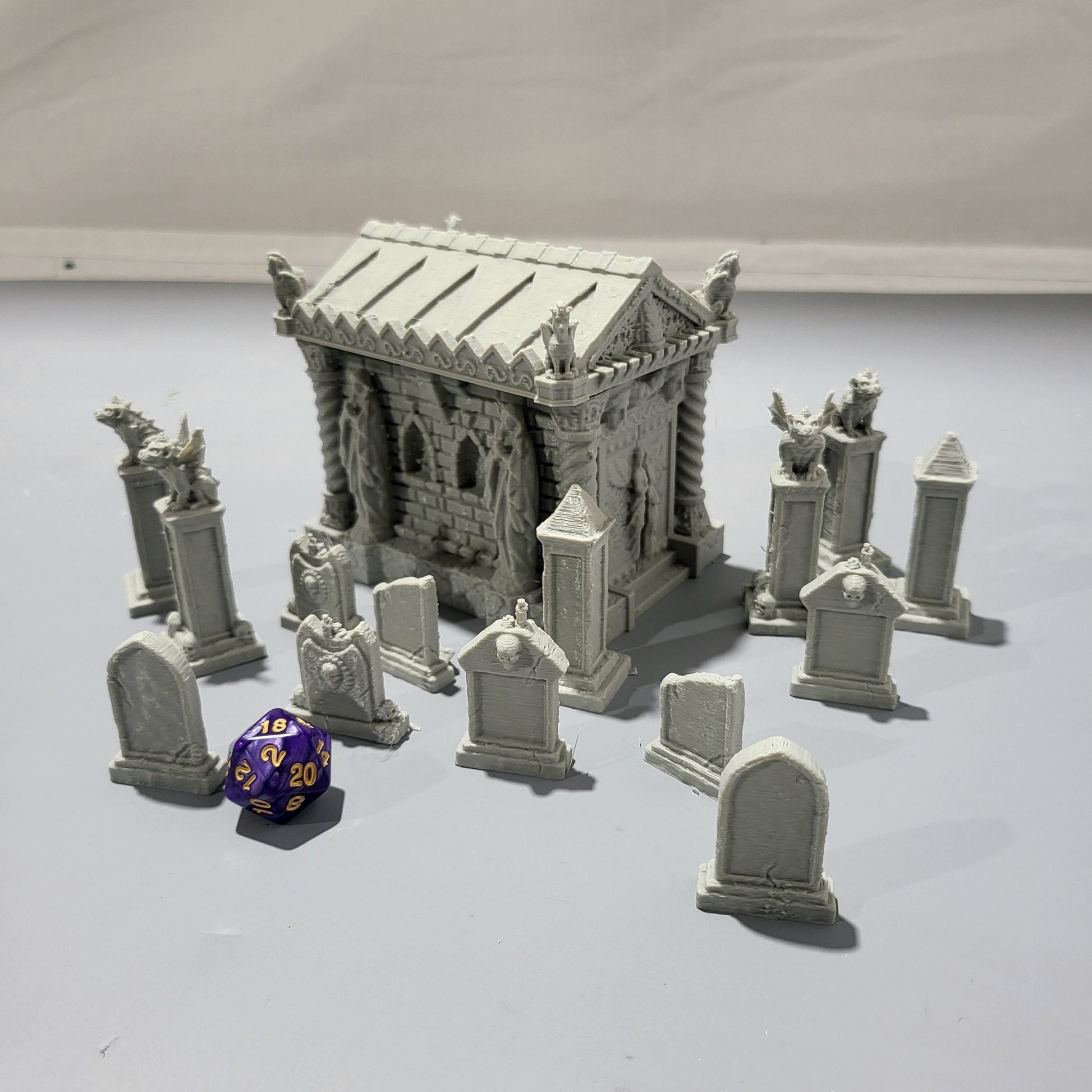 Detailed 15-piece cemetery set for tabletop RPGs, featuring a mausoleum and various gravestones. Perfect for creating eerie graveyard scenes in games like D&D, Pathfinder, and Warhammer.