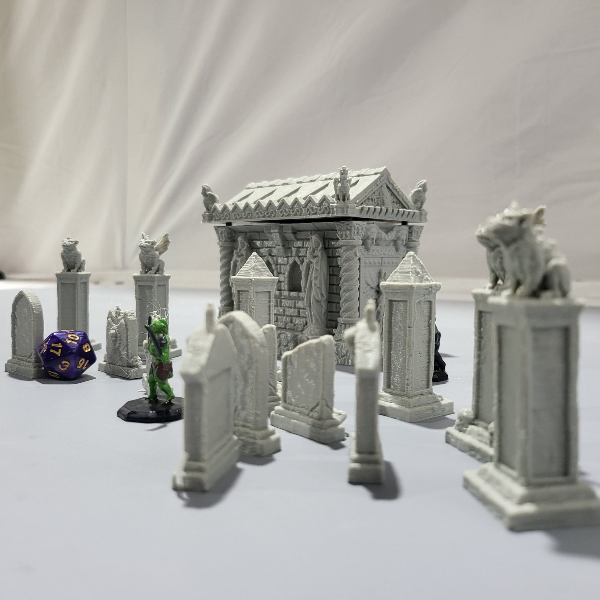 Detailed 15-piece cemetery set for tabletop RPGs, featuring a mausoleum and various gravestones. Perfect for creating eerie graveyard scenes in games like D&D, Pathfinder, and Warhammer.