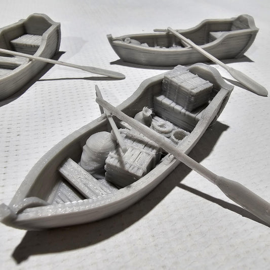Set of 3 medieval rowboats with crates, barrels, sacks, ropes, and oars. Available in 15mm, 28mm, and 32mm scales—perfect for docks, rivers, and coastal scenes in fantasy and historical tabletop games.