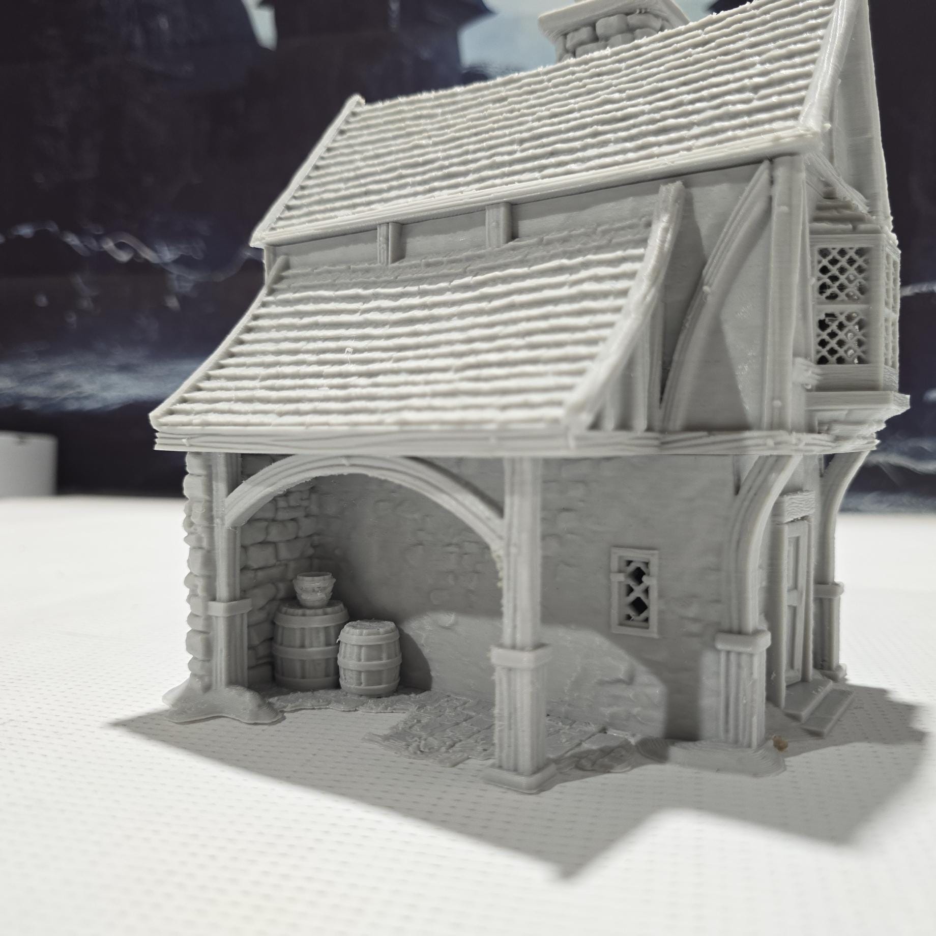 Briarwood House 5 model is a highly detailed medieval half-timbered house, showcasing a classic stone & timber structure. The design includes a steeply pitched roof, a stone chimney, & lattice windows, perfect for enhancing medieval tabletop games