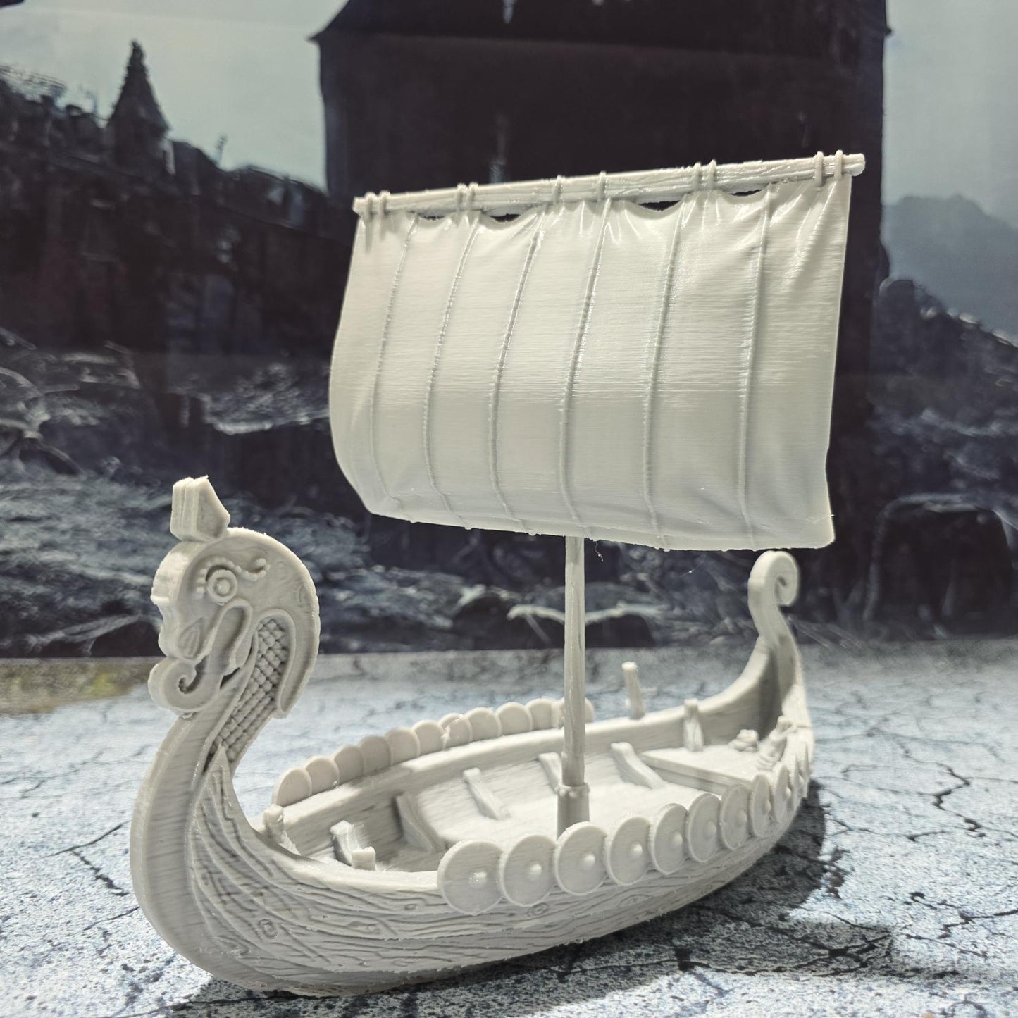 The Viking Invader Ship model features a detailed dragon-head prow, shield-lined sides, and a furled sail, capturing the essence of Norse seafaring prowess, perfect for bringing epic Viking adventures to life on your tabletop.