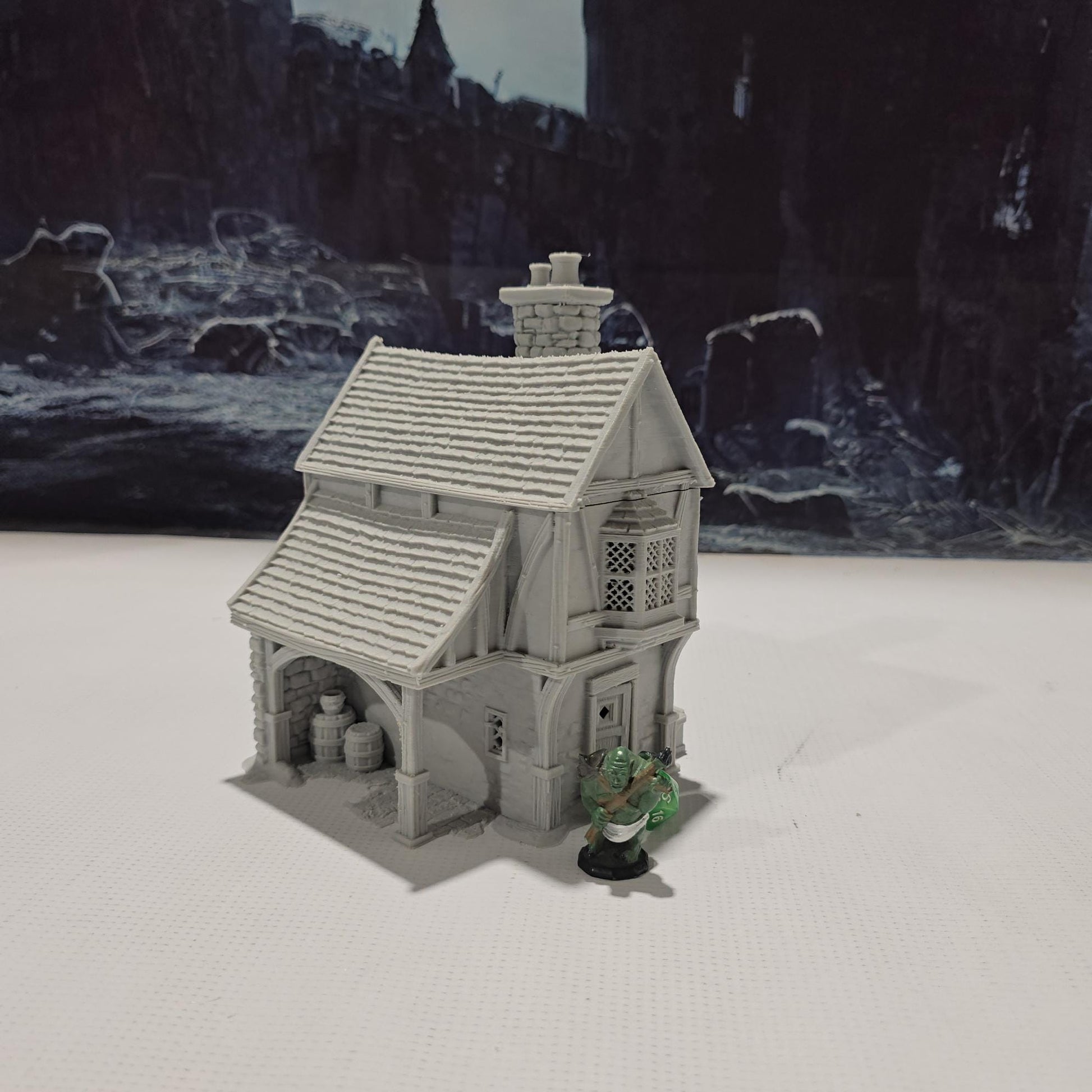 Briarwood House 5 model is a highly detailed medieval half-timbered house, showcasing a classic stone & timber structure. The design includes a steeply pitched roof, a stone chimney, & lattice windows, perfect for enhancing medieval tabletop games