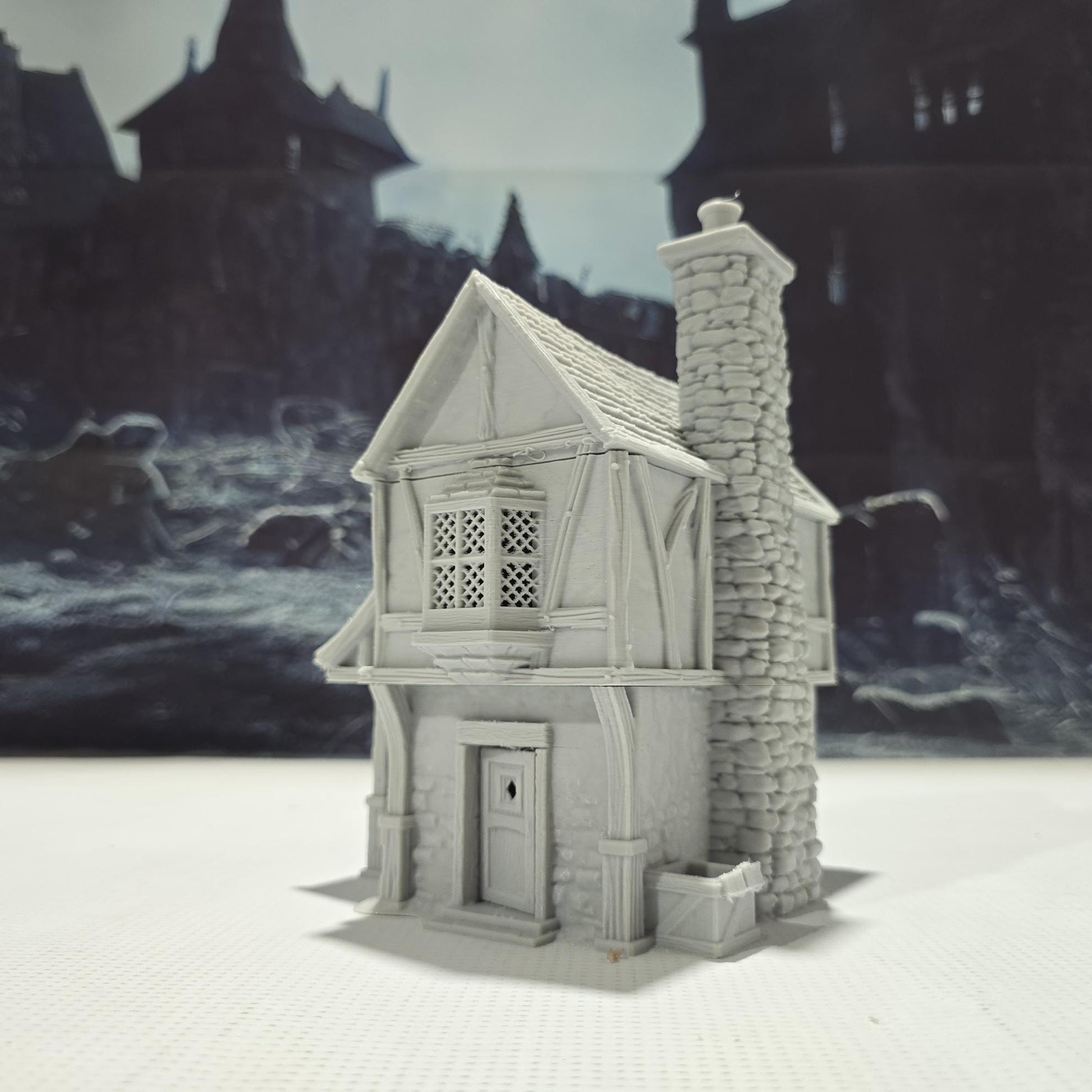 Briarwood House 5 model is a highly detailed medieval half-timbered house, showcasing a classic stone & timber structure. The design includes a steeply pitched roof, a stone chimney, & lattice windows, perfect for enhancing medieval tabletop games