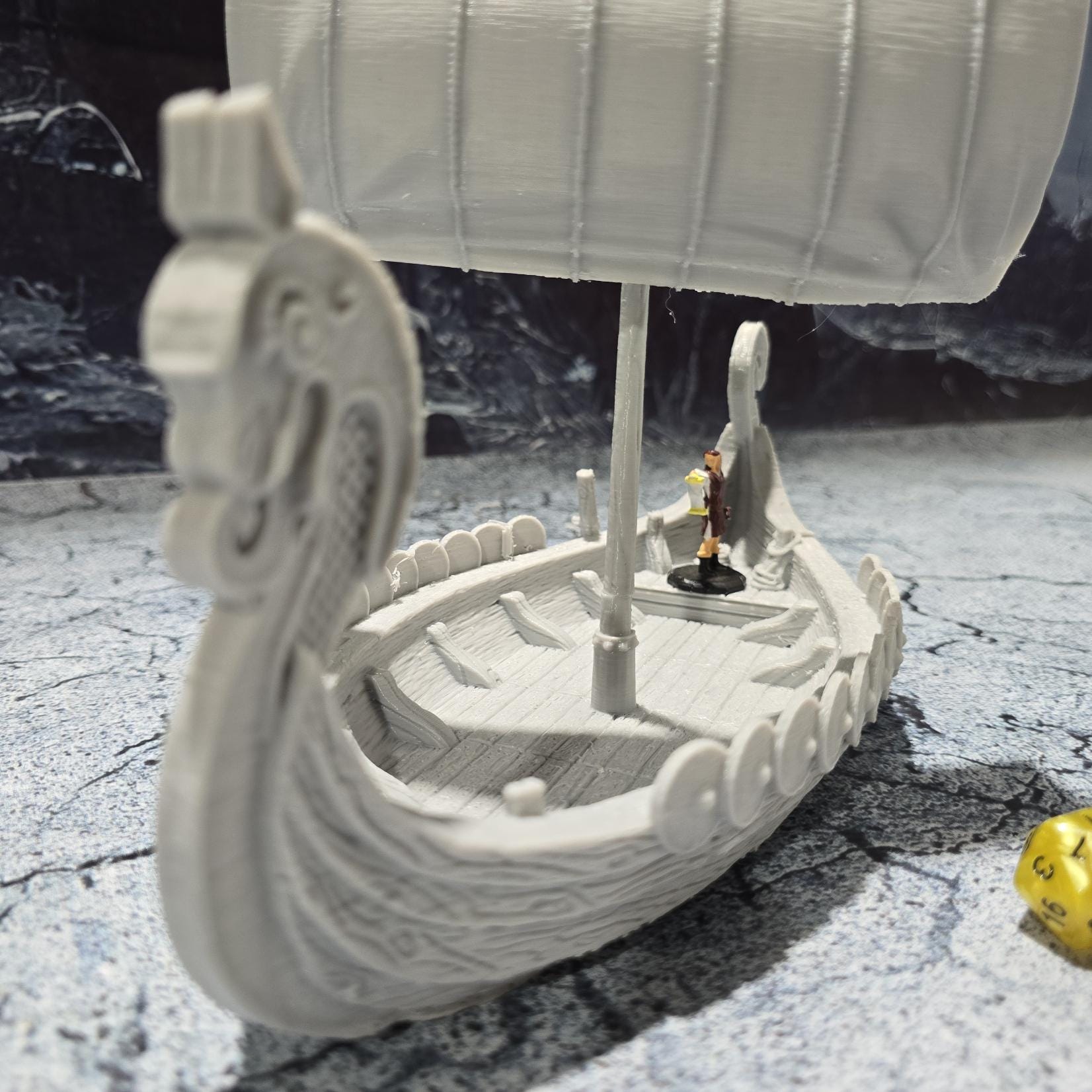 The Viking Invader Ship model features a detailed dragon-head prow, shield-lined sides, and a furled sail, capturing the essence of Norse seafaring prowess, perfect for bringing epic Viking adventures to life on your tabletop.
