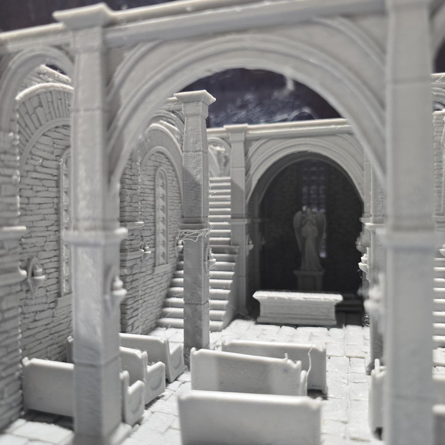 The Greendale Church of the Dale features a medieval gothic design with two angel statues and sets of pews, ideal for historical tabletop settings.