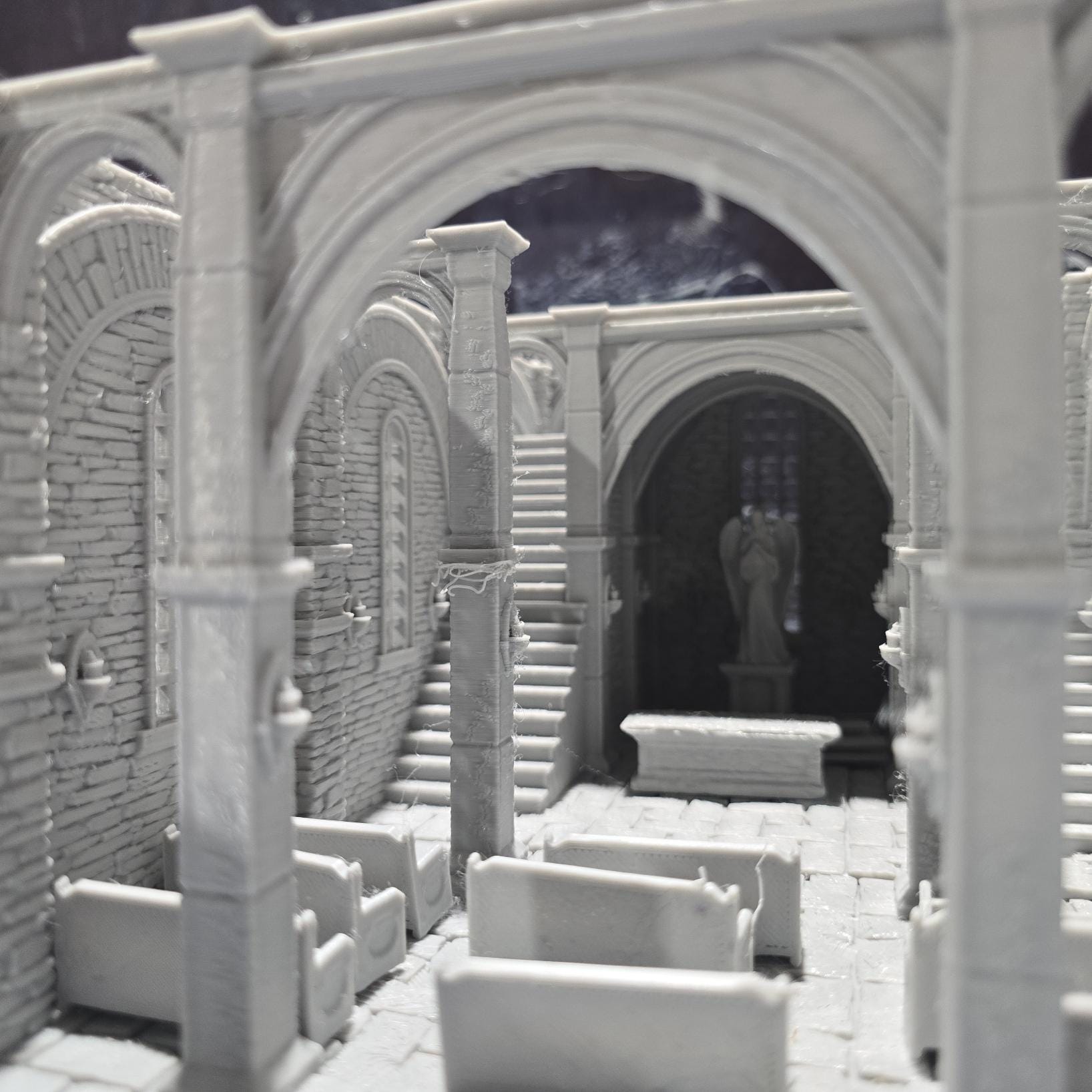 The Greendale Church of the Dale features a medieval gothic design with two angel statues and sets of pews, ideal for historical tabletop settings.