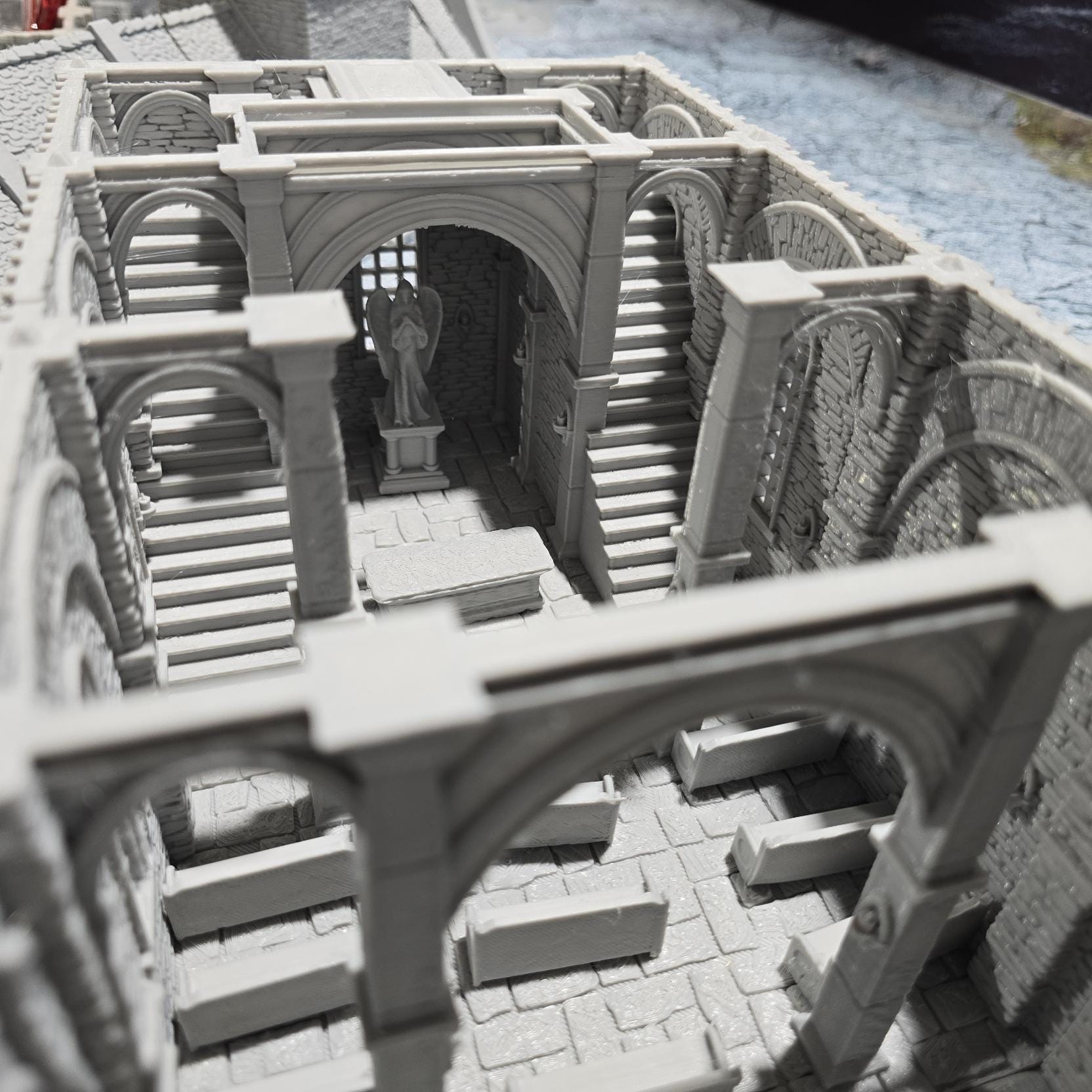 The Greendale Church of the Dale features a medieval gothic design with two angel statues and sets of pews, ideal for historical tabletop settings.