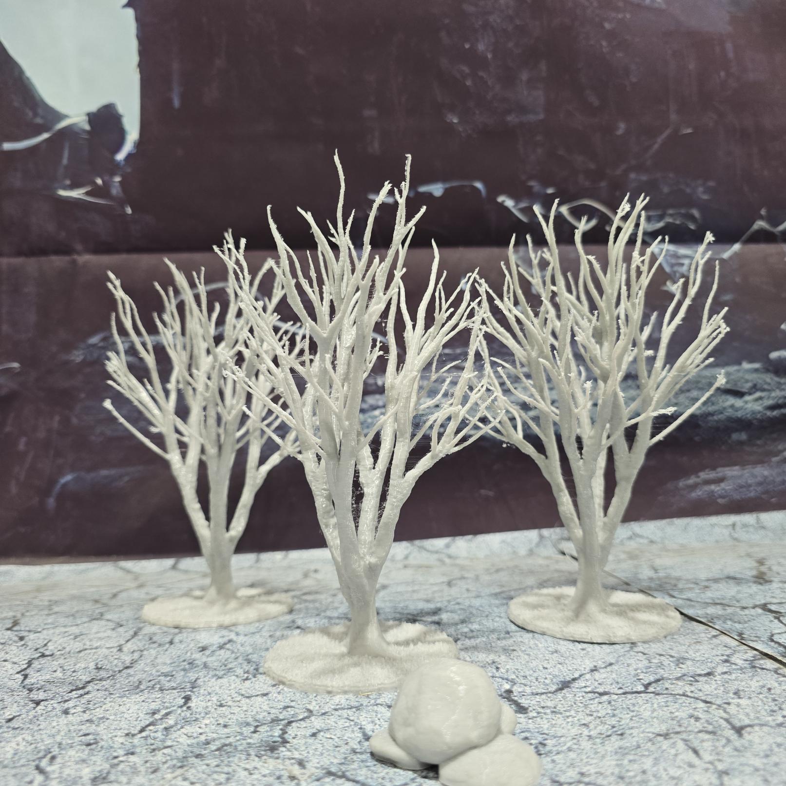 A set of 3 bare trees, each featuring intricate branches and a stable base. Perfect for creating desolate or haunted landscapes in tabletop RPGs and dioramas. Ideal for use in wintery or eerie settings.