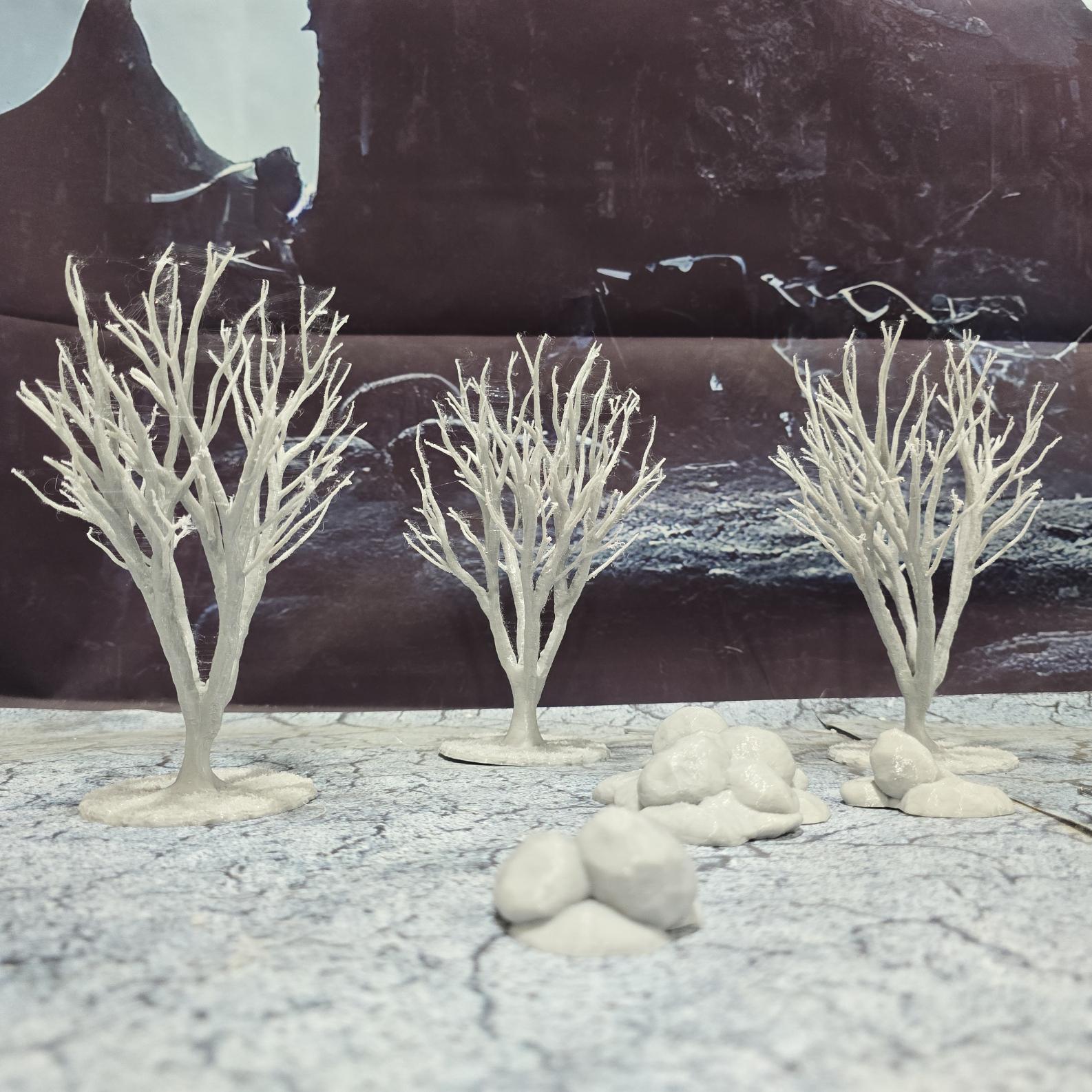 A set of 3 bare trees, each featuring intricate branches and a stable base. Perfect for creating desolate or haunted landscapes in tabletop RPGs and dioramas. Ideal for use in wintery or eerie settings.