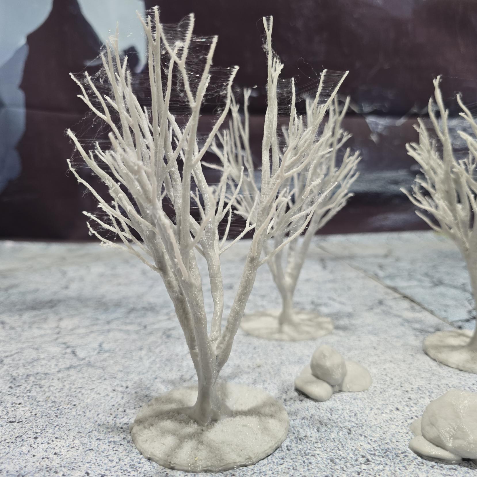 A set of 3 bare trees, each featuring intricate branches and a stable base. Perfect for creating desolate or haunted landscapes in tabletop RPGs and dioramas. Ideal for use in wintery or eerie settings.