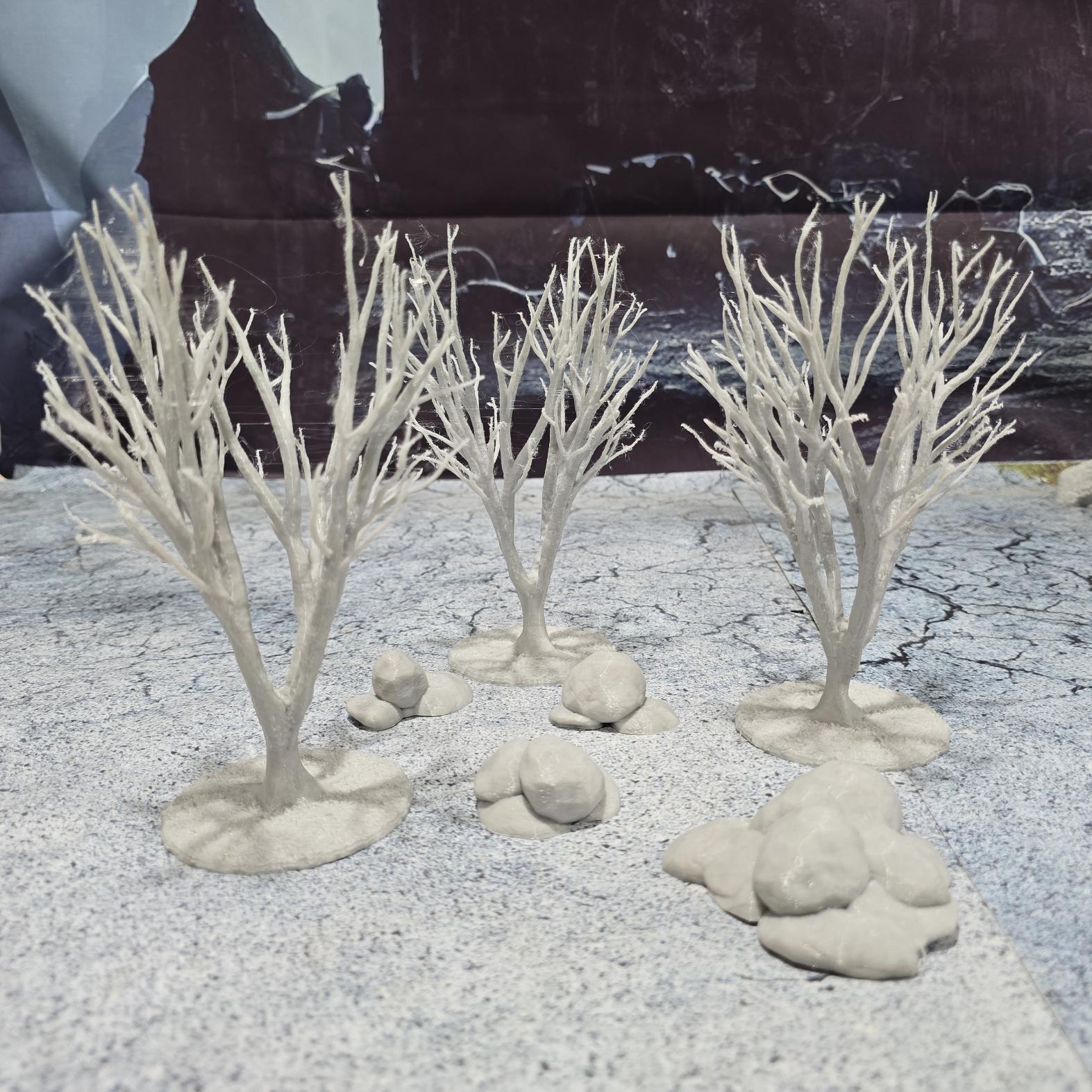 A set of 3 bare trees, each featuring intricate branches and a stable base. Perfect for creating desolate or haunted landscapes in tabletop RPGs and dioramas. Ideal for use in wintery or eerie settings.