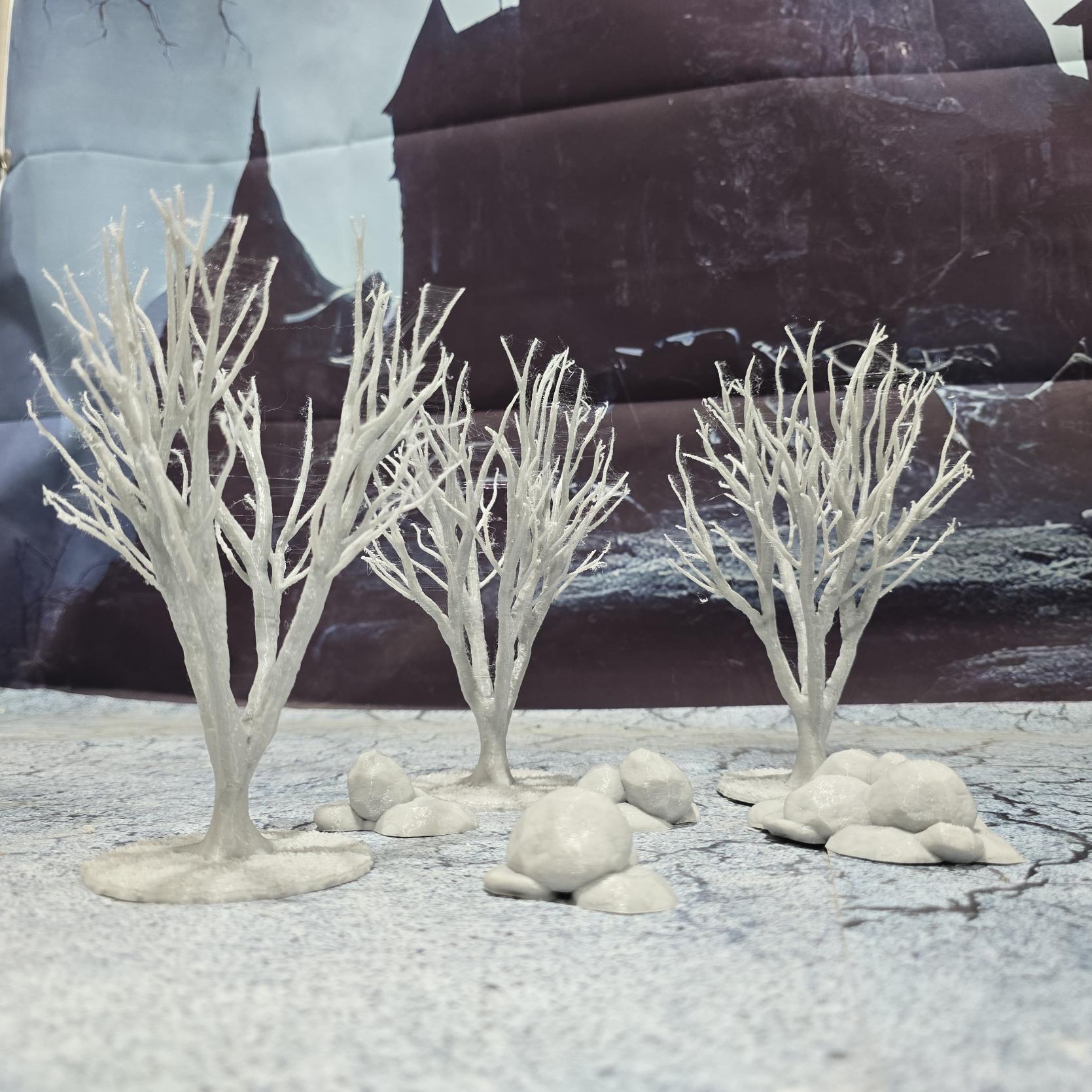 A set of 3 bare trees, each featuring intricate branches and a stable base. Perfect for creating desolate or haunted landscapes in tabletop RPGs and dioramas. Ideal for use in wintery or eerie settings.