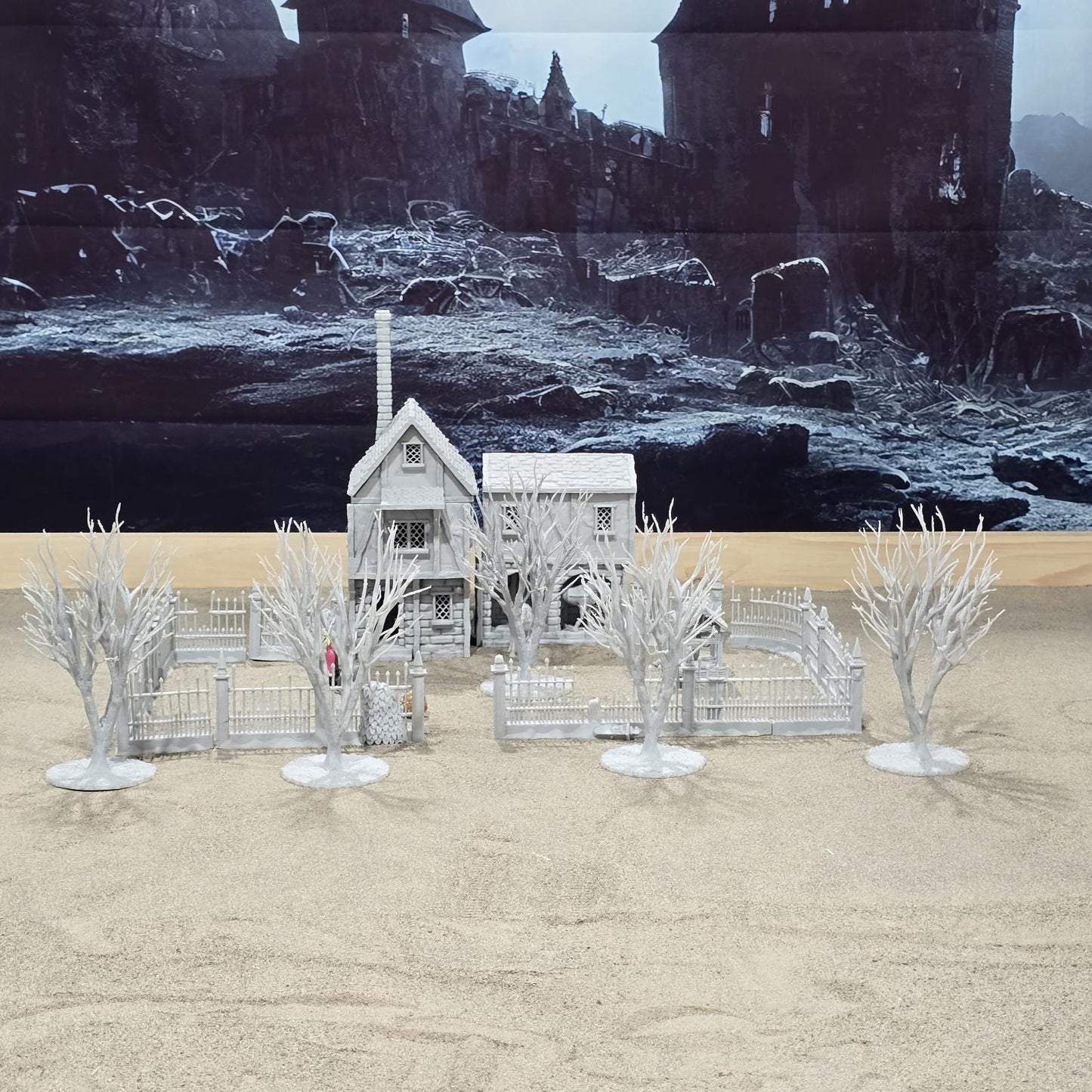 Exquisite 3D printed homestead model with detailed house, fencing, and barren trees, set against a rugged backdrop, perfect for tabletop games and dioramas.