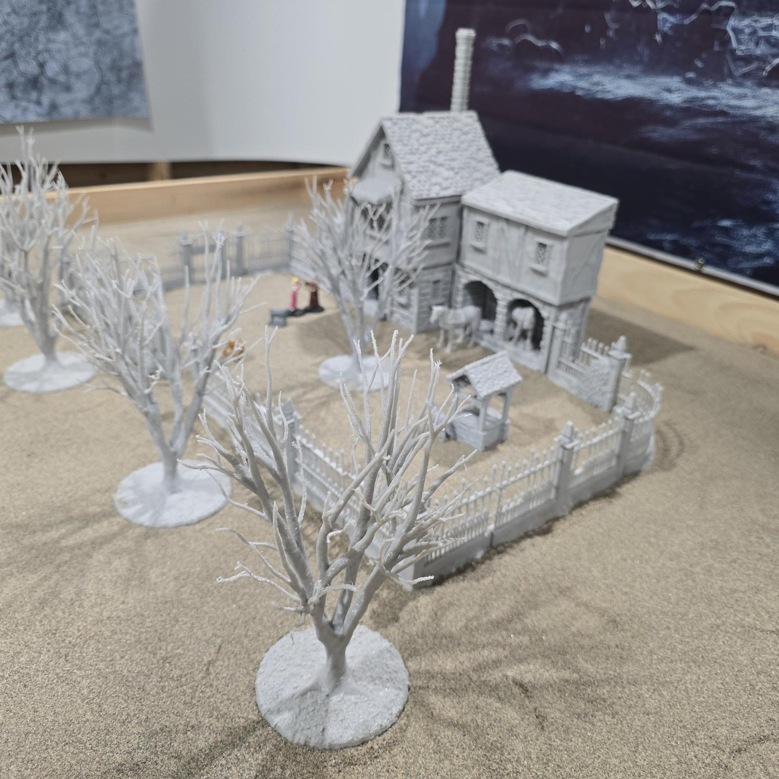 Exquisite 3D printed homestead model with detailed house, fencing, and barren trees, set against a rugged backdrop, perfect for tabletop games and dioramas.