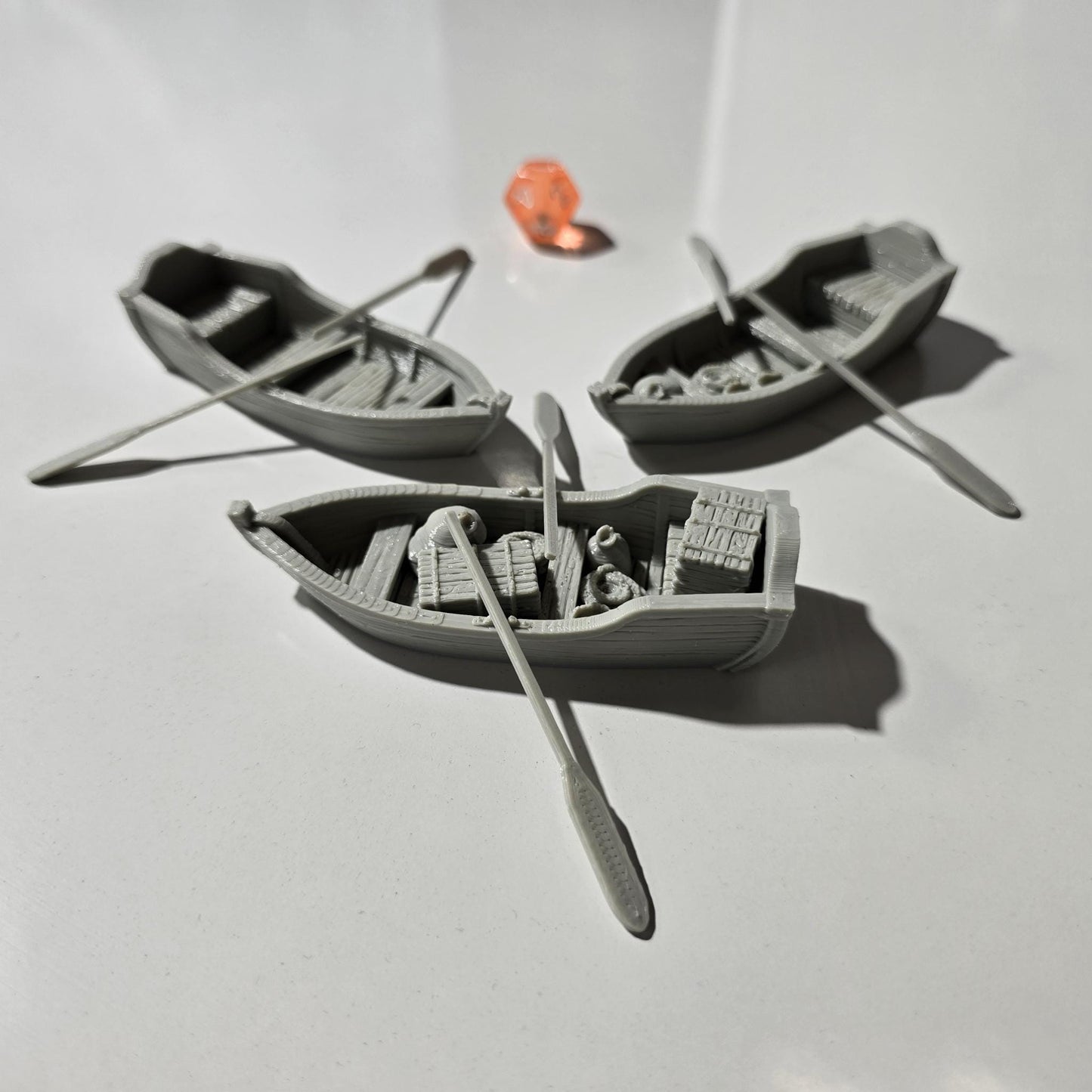 Set of 3 medieval rowboats with crates, barrels, sacks, ropes, and oars. Available in 15mm, 28mm, and 32mm scales—perfect for docks, rivers, and coastal scenes in fantasy and historical tabletop games.