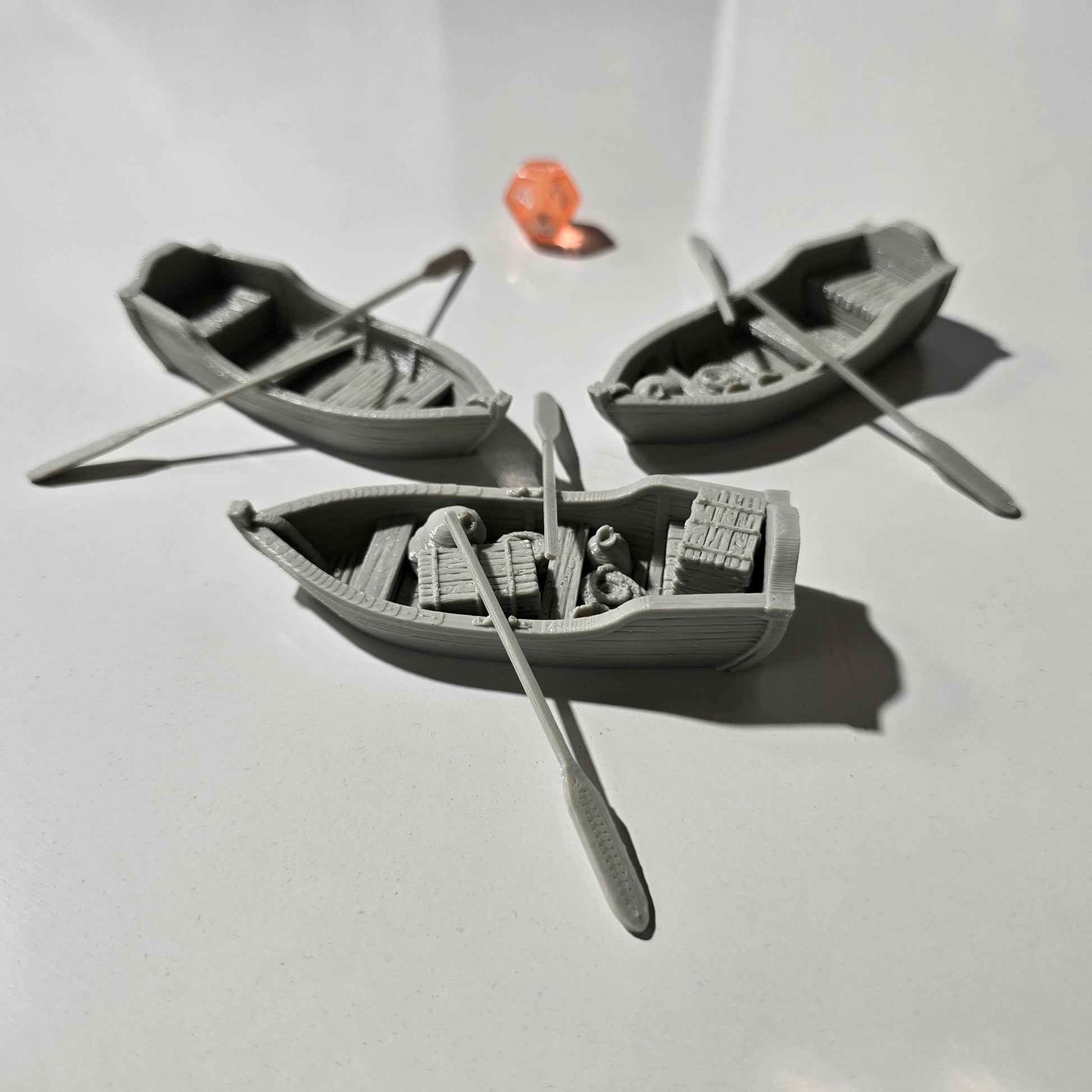 Set of 3 medieval rowboats with crates, barrels, sacks, ropes, and oars. Available in 15mm, 28mm, and 32mm scales—perfect for docks, rivers, and coastal scenes in fantasy and historical tabletop games.