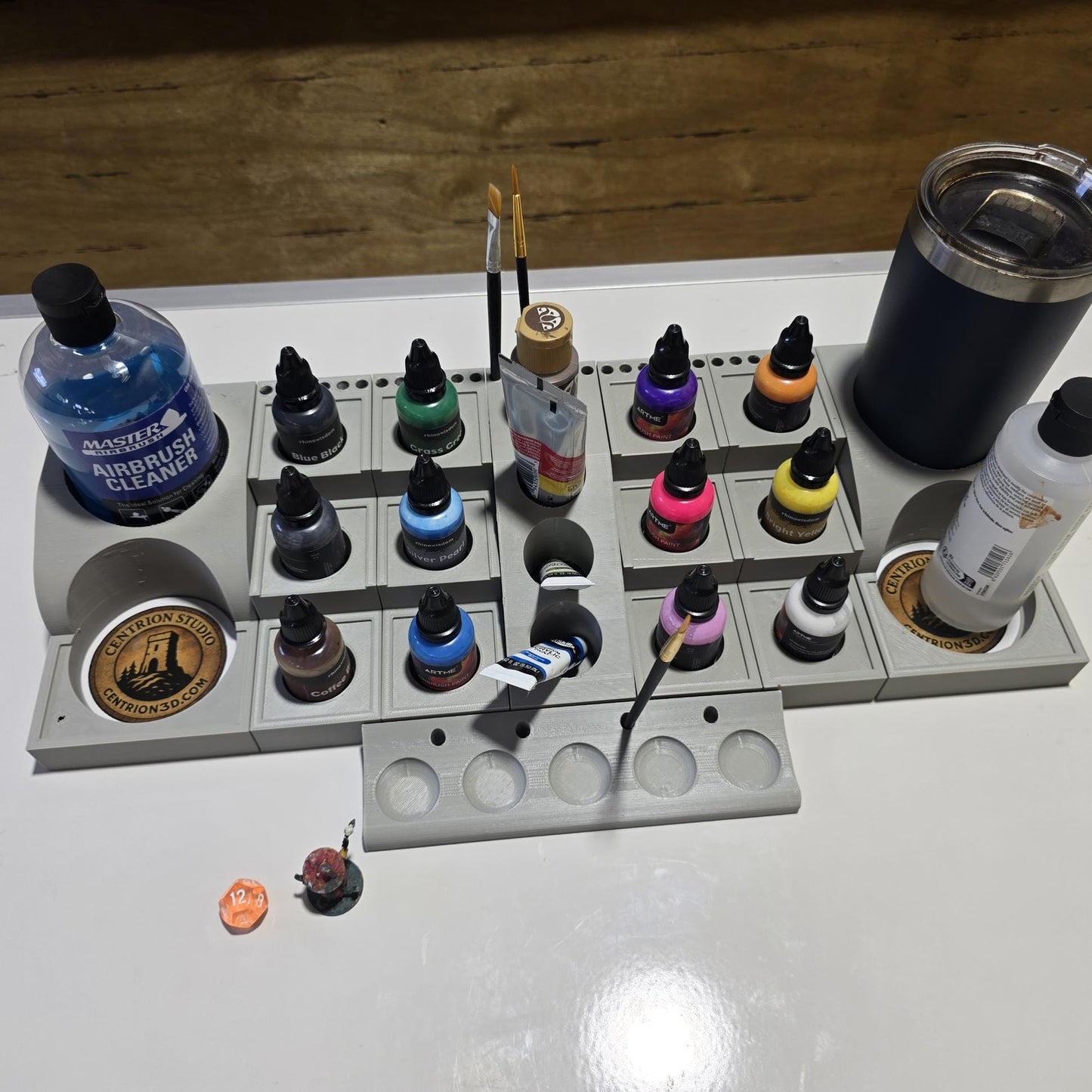 Expandable hobby organizer with paint bottles and brushes displayed on desk