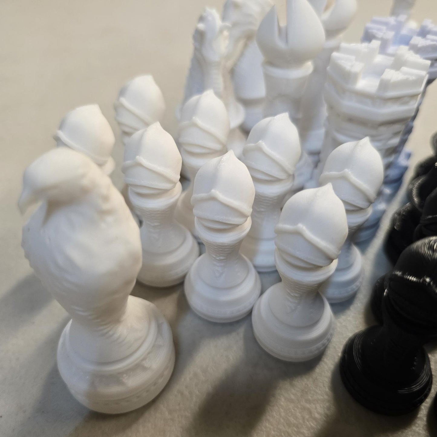 White 3D printed chess pieces including pawns, rook, knight, bishop, queen and king from medieval castle chess set