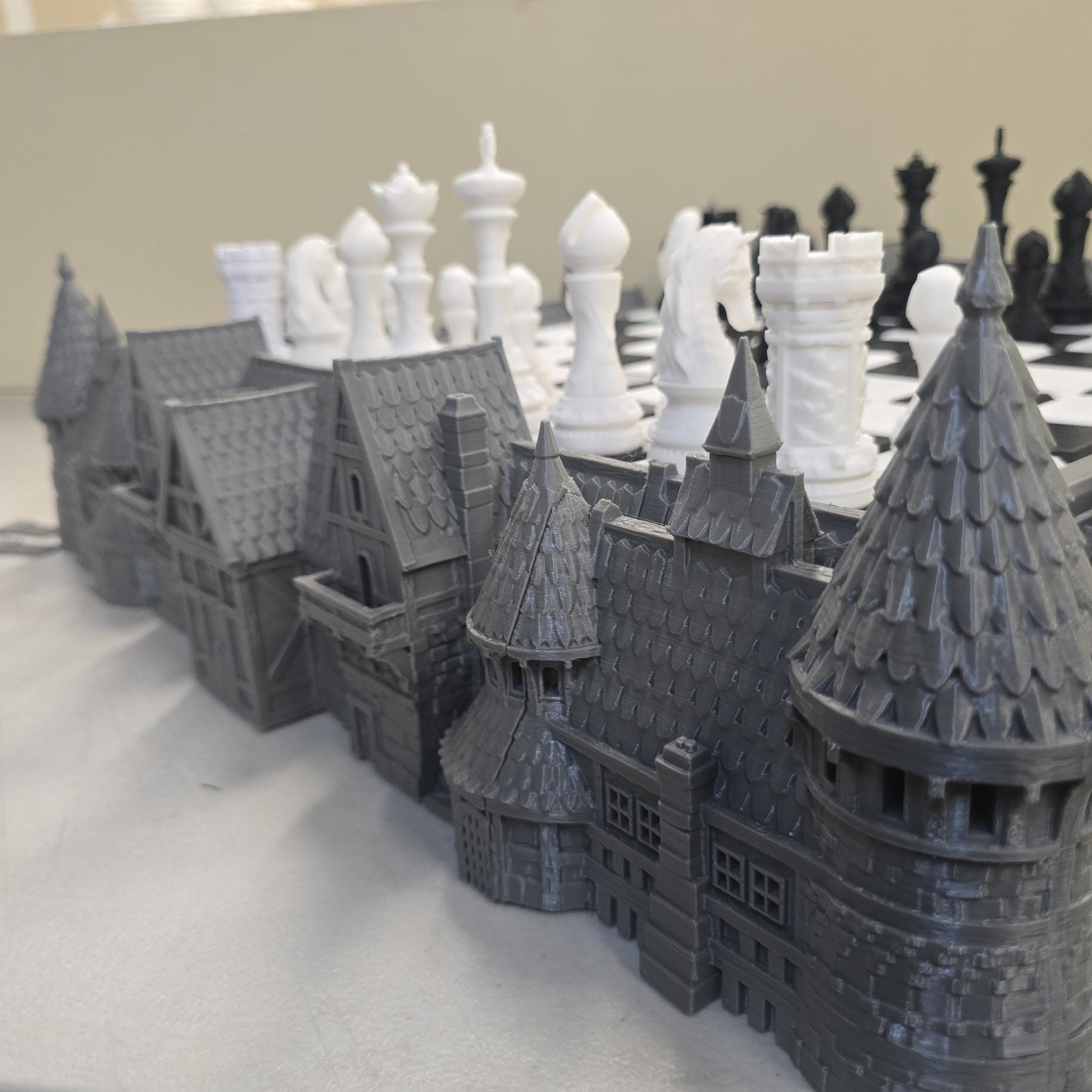 3D printed castle base surrounding raised chess board with towers, rooftops and stone wall detailing