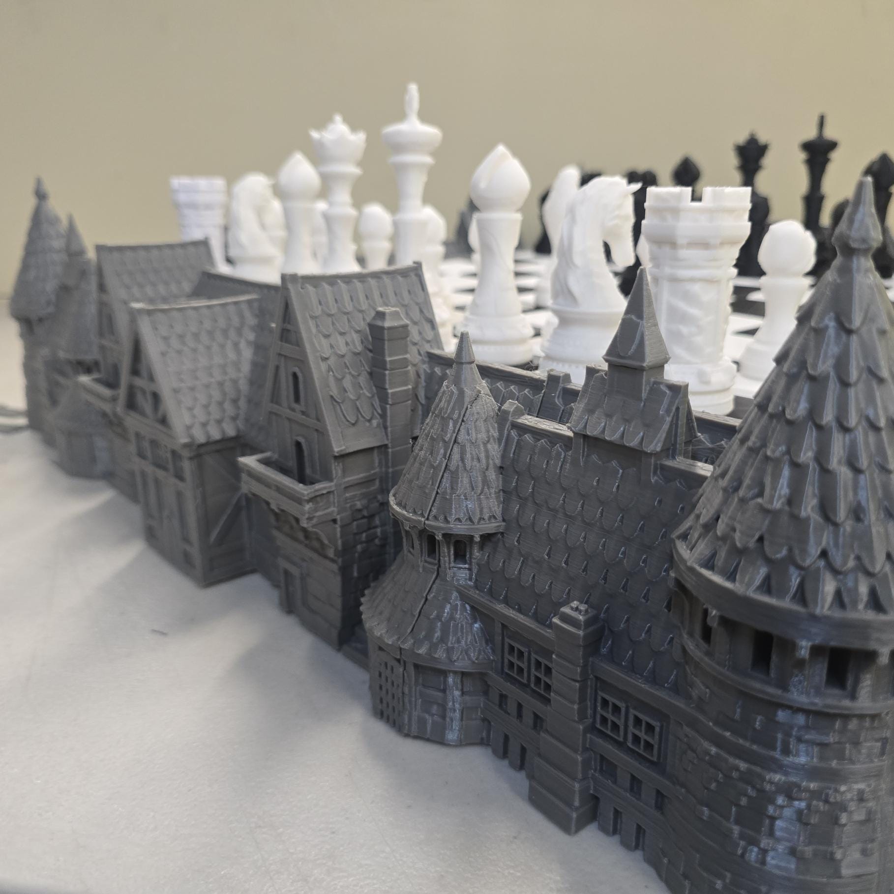 3D printed castle base surrounding raised chess board with towers, rooftops and stone wall detailing