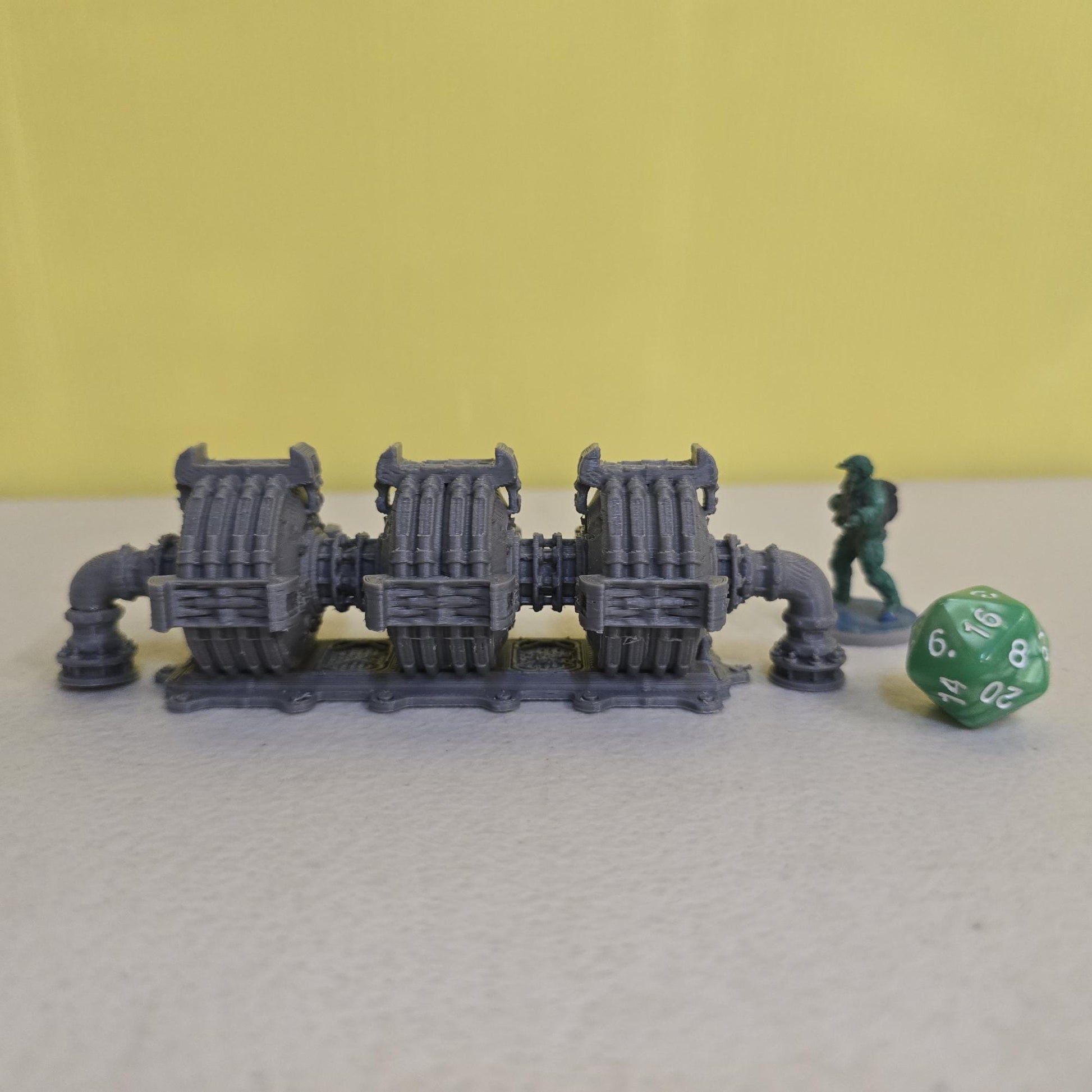 Grimdark power generator cells with ribbed housings, arched industrial frames, vent stacks, and curved pipe connections. Scaled for DnD / Pathfinder / wargaming. Miniatures and a D20 to show their footprint on a 1-inch grid. Several variants appear as single units and linked multi-cell arrays, giving the set the look of a dense industrial power system. Built as sci-fi scatter terrain, these generator cells bring heavy mechanical detail and battlefield atmosphere to any tabletop terrain layout.