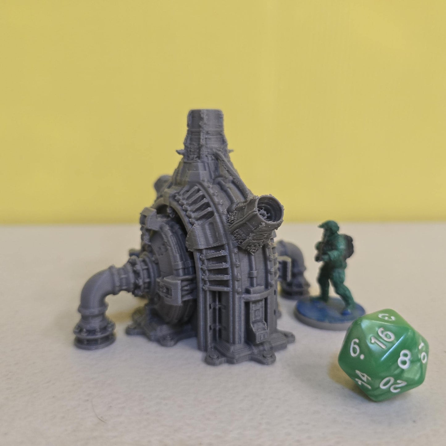 Grimdark power generator cells with ribbed housings, arched industrial frames, vent stacks, and curved pipe connections. Scaled for DnD / Pathfinder / wargaming. Miniatures and a D20 to show their footprint on a 1-inch grid. Several variants appear as single units and linked multi-cell arrays, giving the set the look of a dense industrial power system. Built as sci-fi scatter terrain, these generator cells bring heavy mechanical detail and battlefield atmosphere to any tabletop terrain layout.